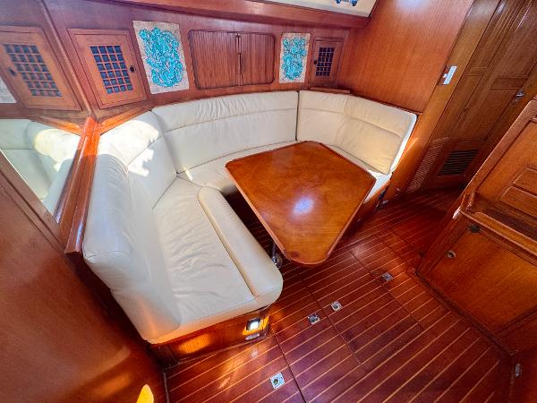 1983 Tayana 52 Aft Cockpit interior with wooden table and cream seating.