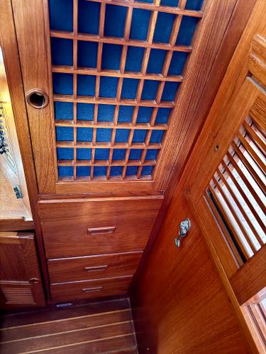 Wooden interior of 1983 Tayana 52 Aft Cockpit sailboat with lattice cabinet and drawers.