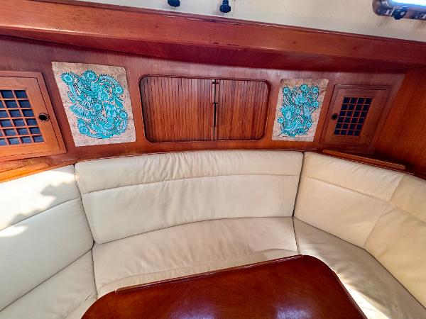 Interior of 1983 Tayana 52 Aft Cockpit with cream seating and wooden accents.