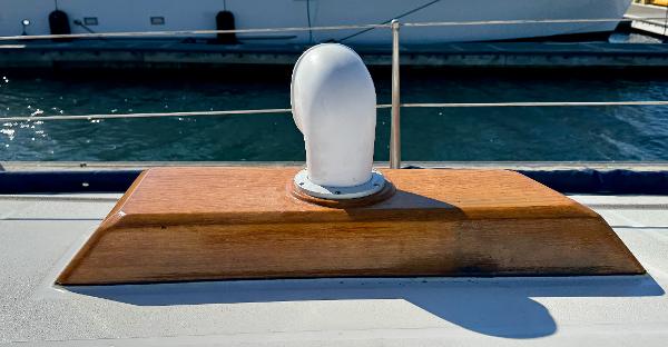 Wooden deck vent on 1983 Tayana 52 Aft Cockpit yacht, docked by the water.