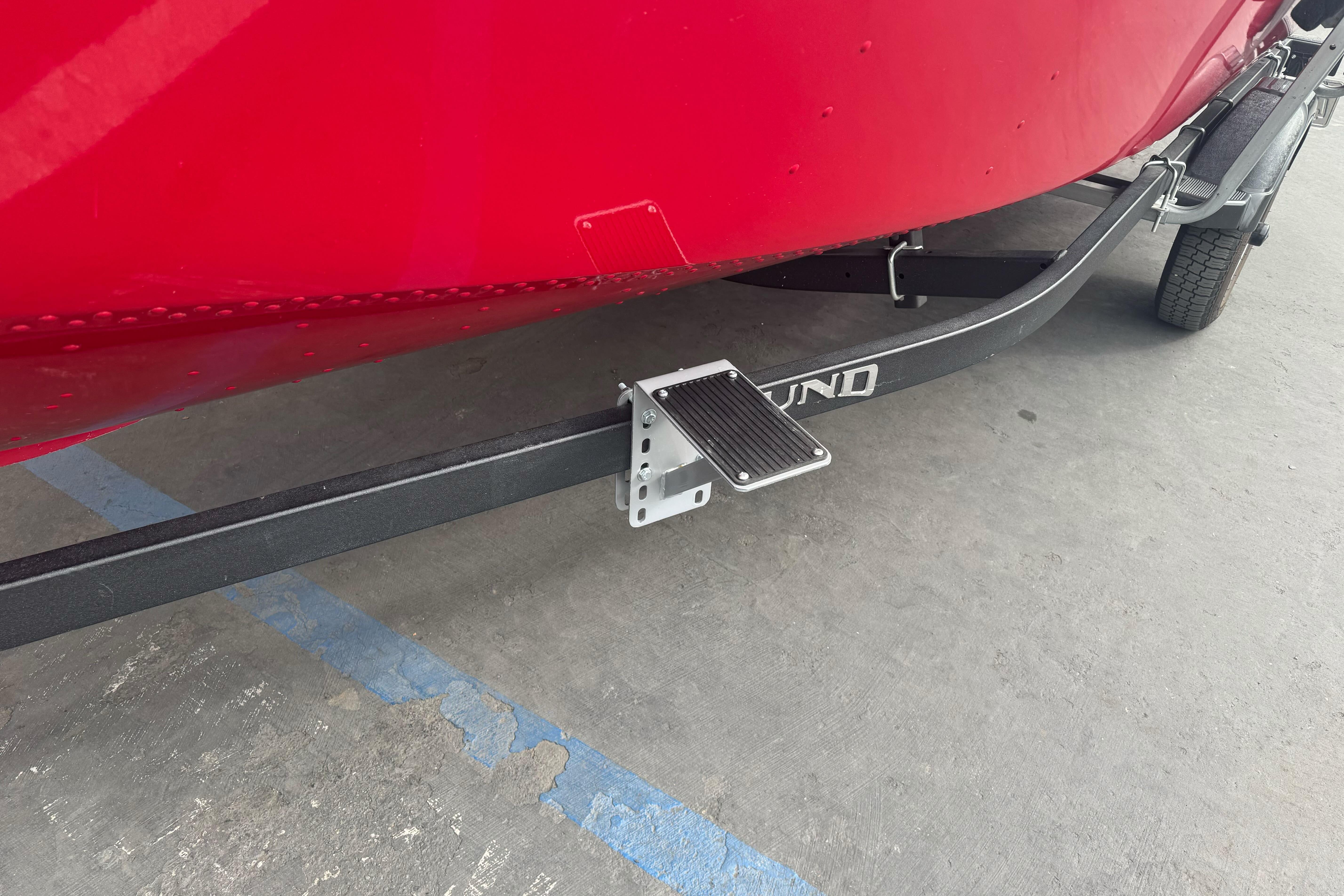 Red 2021 Lund 1650 Angler SS boat on trailer with step platform.