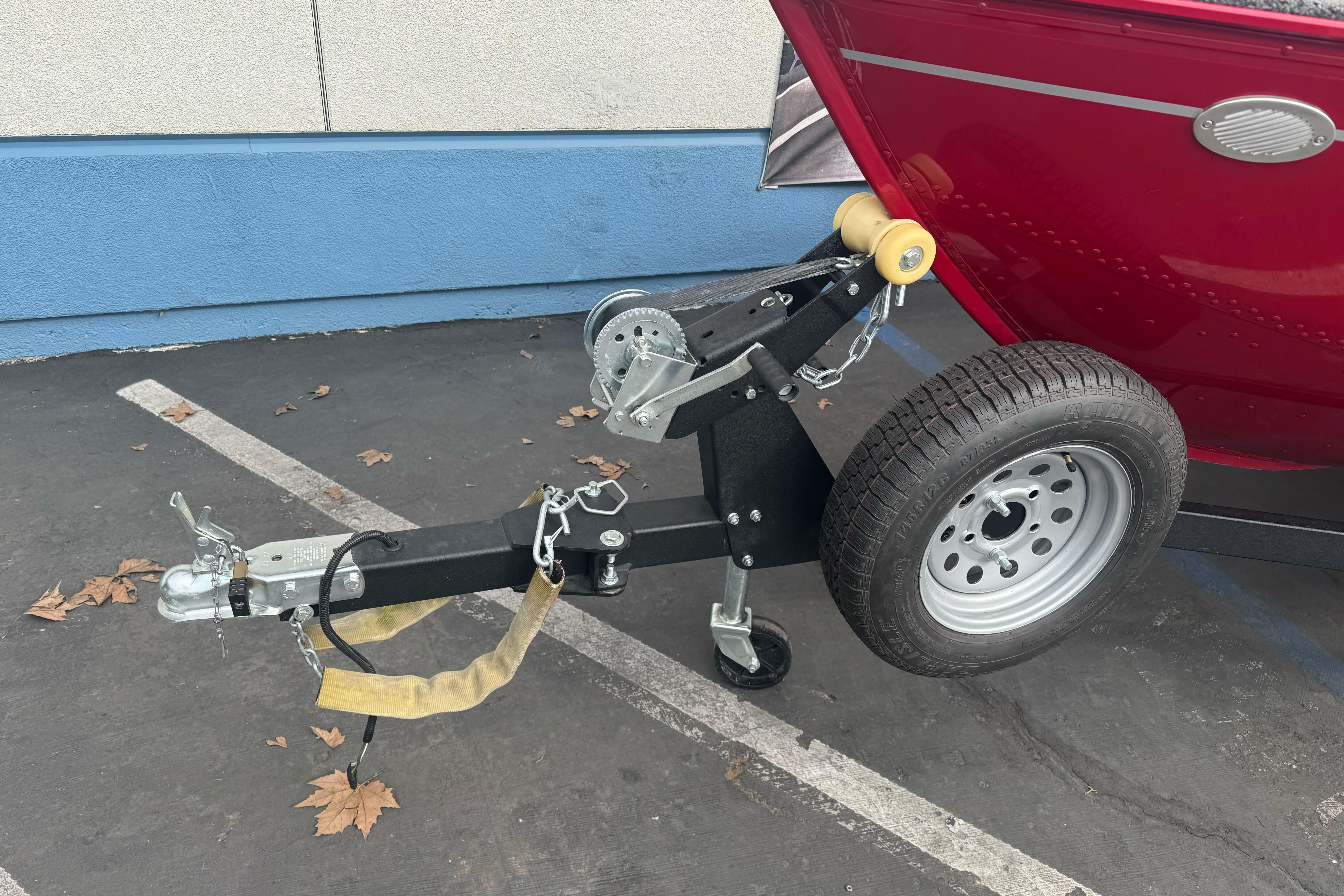 Trailer hitch of a 2021 Lund 1650 Angler SS boat in a parking lot.