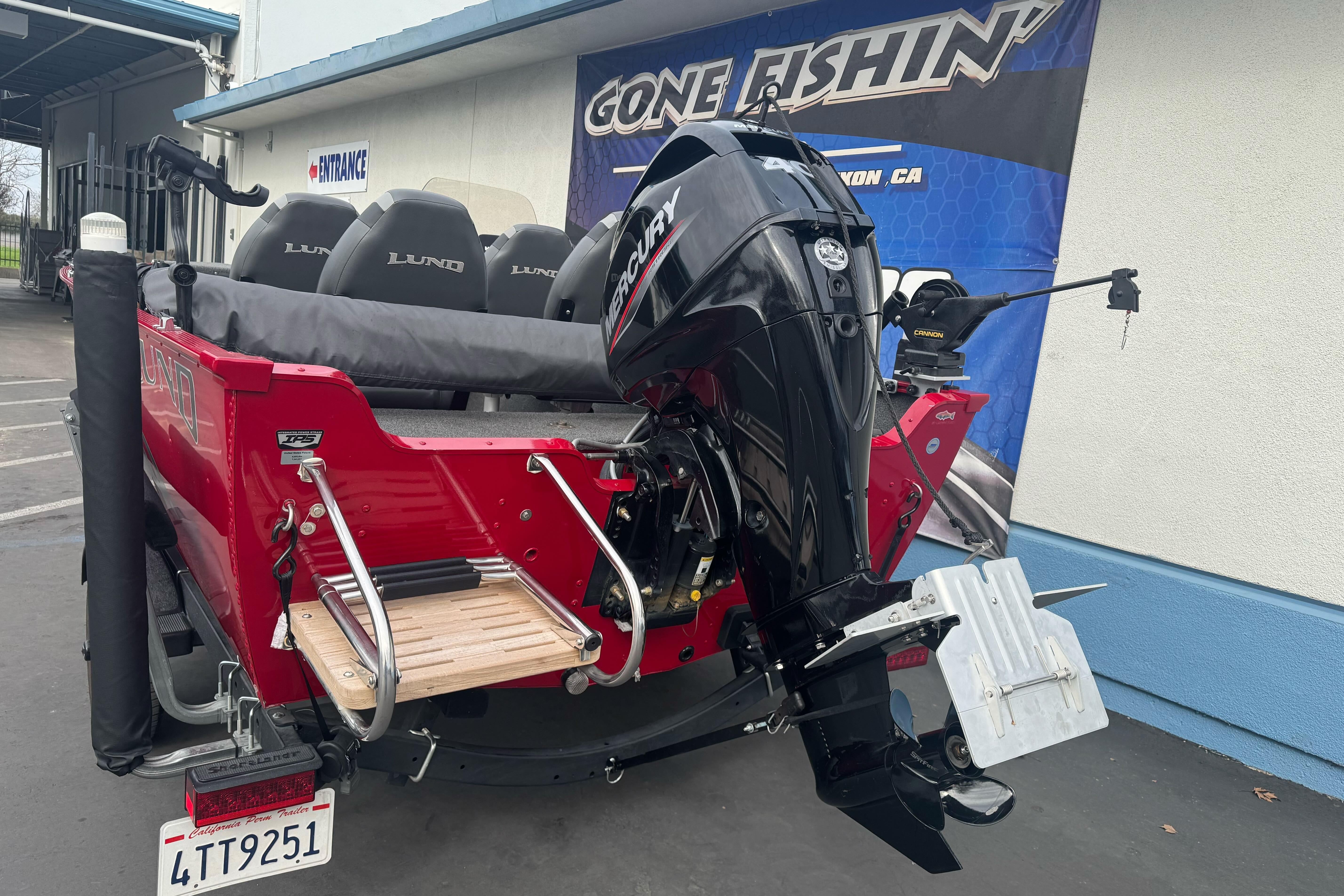 2021 Lund 1650 Angler SS boat with Mercury outboard motor, parked at dealership.