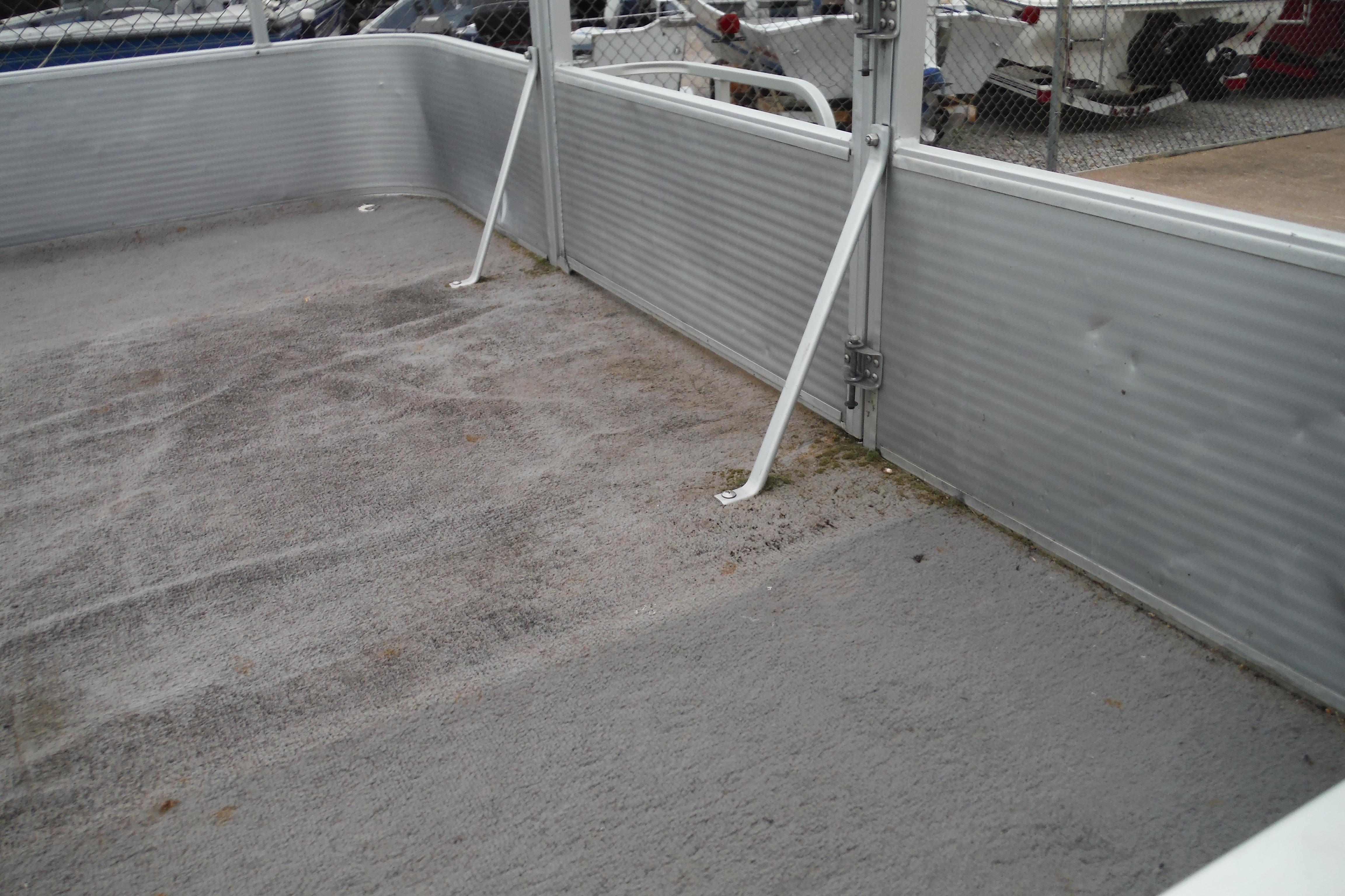 1989 Sea Nymph SS200 SUNCRUISER deck with gray carpet and metal railing.