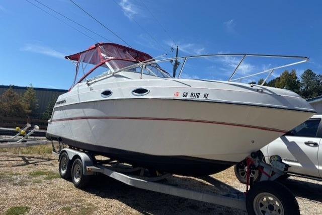 2000 Four Winns 238 Vista boat on trailer, red canopy, parked outdoors.