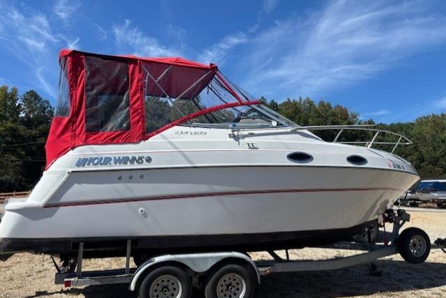 2000 Four Winns 238 Vista boat with red canopy on a trailer.