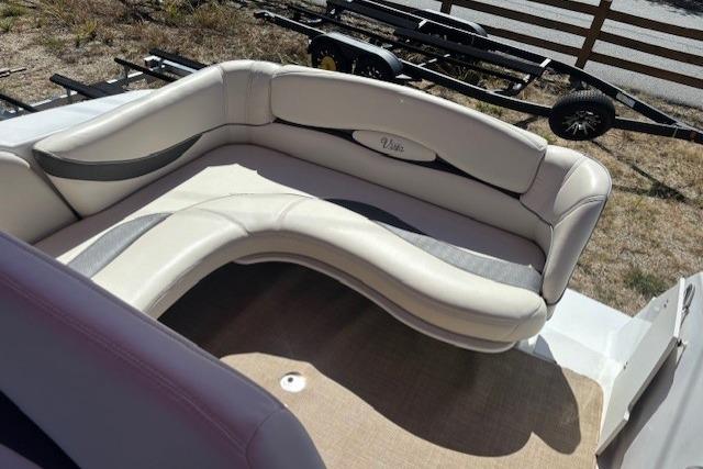 2000 Four Winns 238 Vista boat interior with curved seating and beige upholstery.