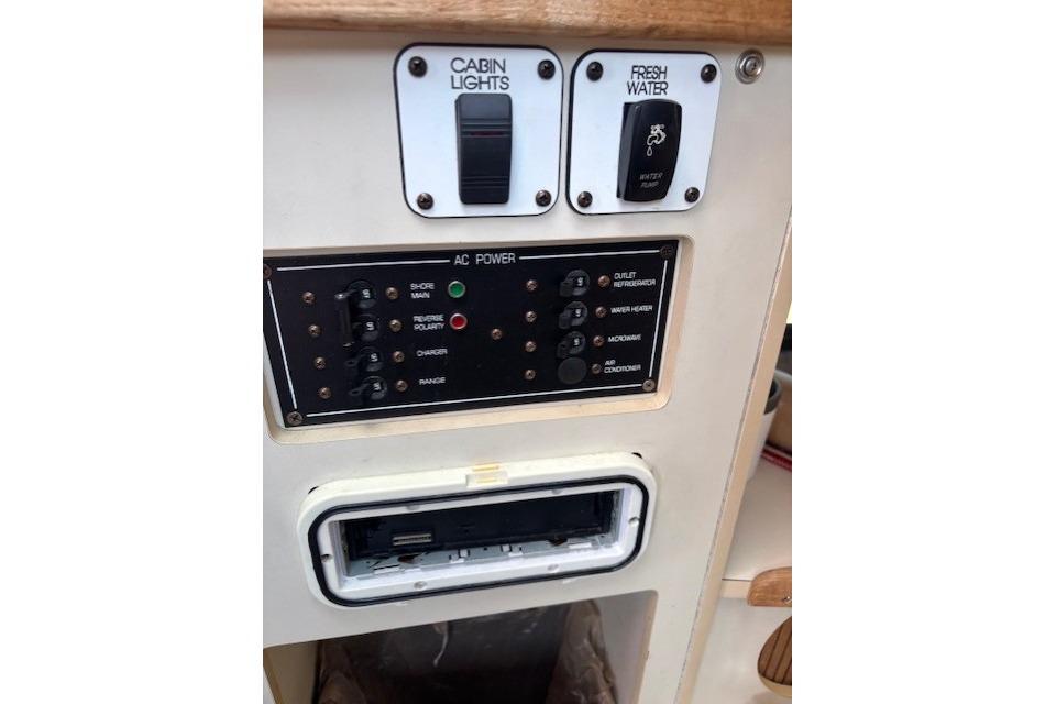 Control panel of a 2000 Four Winns 238 Vista boat, featuring cabin lights and AC power switches.