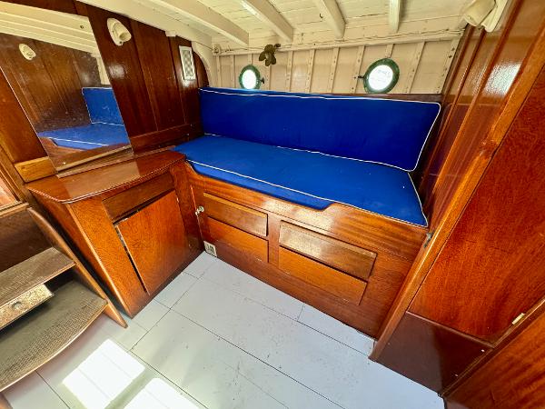 Interior of 1966 Rampart 48 boat with wooden furnishings and blue cushioned seating.