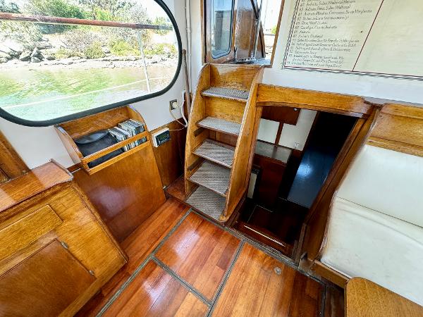Interior of a 1966 Rampart 48 boat with wooden flooring and stairs.