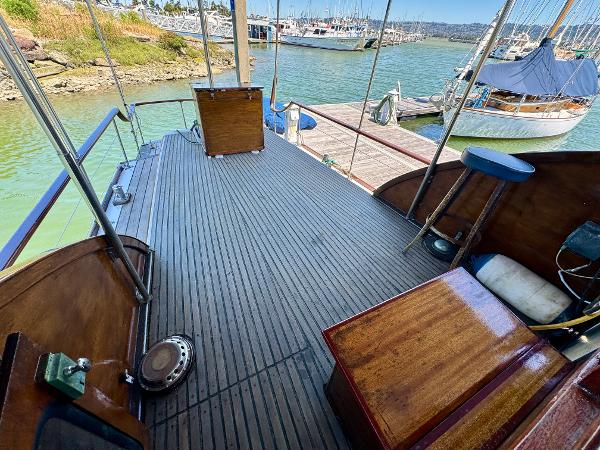Wooden deck of a 1966 Rampart 48 boat docked at a marina.