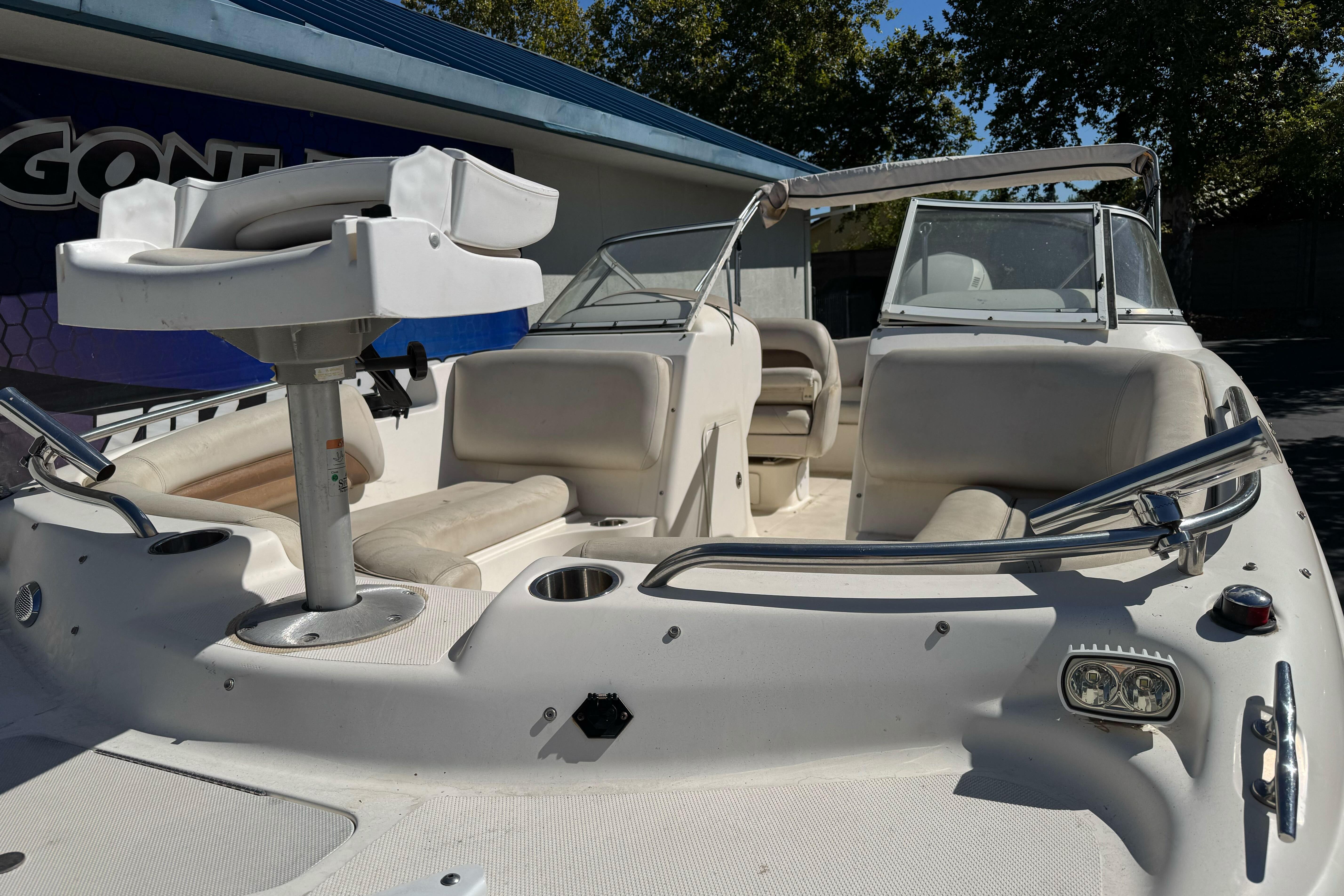 2007 Hurricane SunDeck 217 OB boat with seating and steering console, docked outdoors.