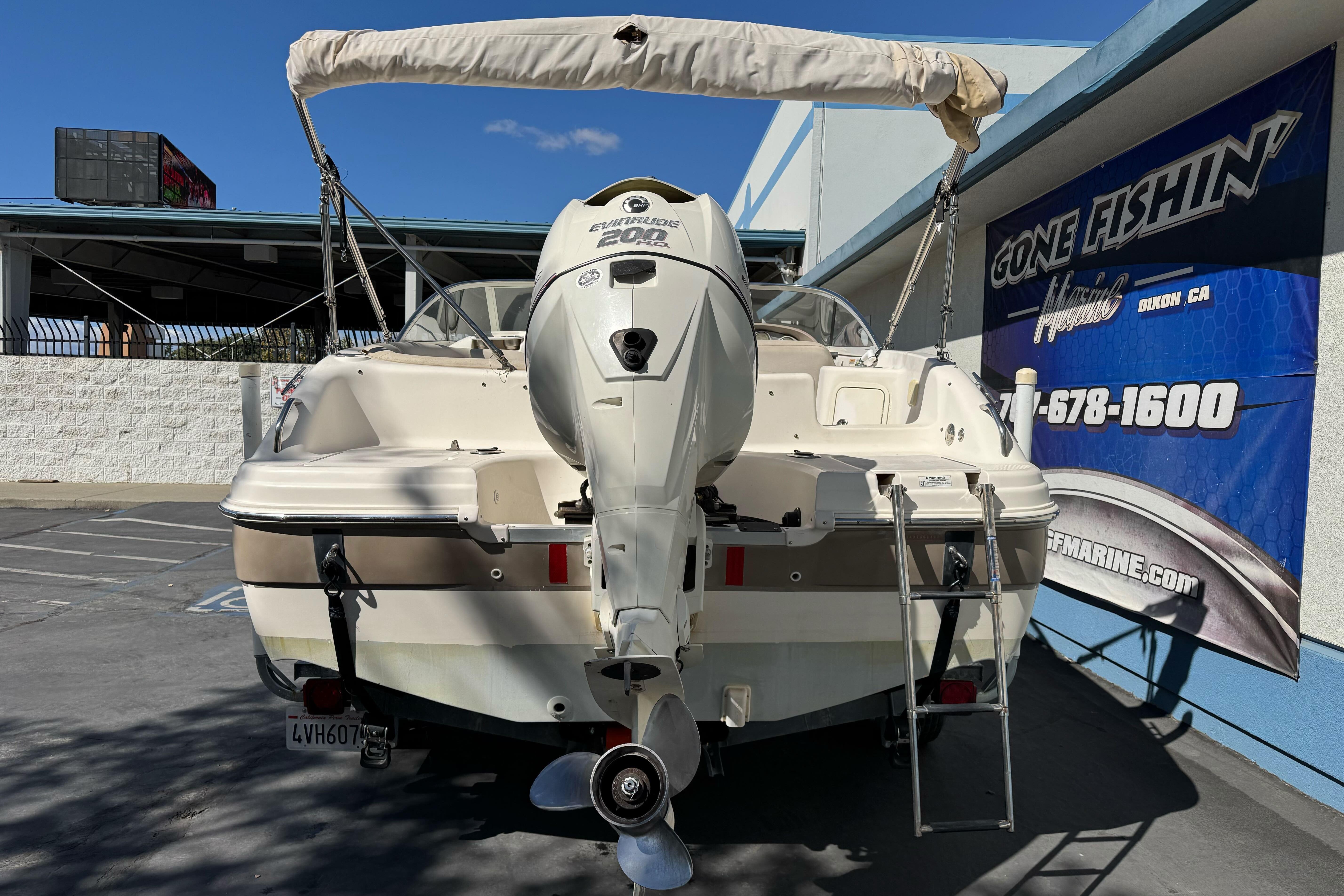 2007 Hurricane SunDeck 217 OB boat with Evinrude 200 engine, parked at dealership.