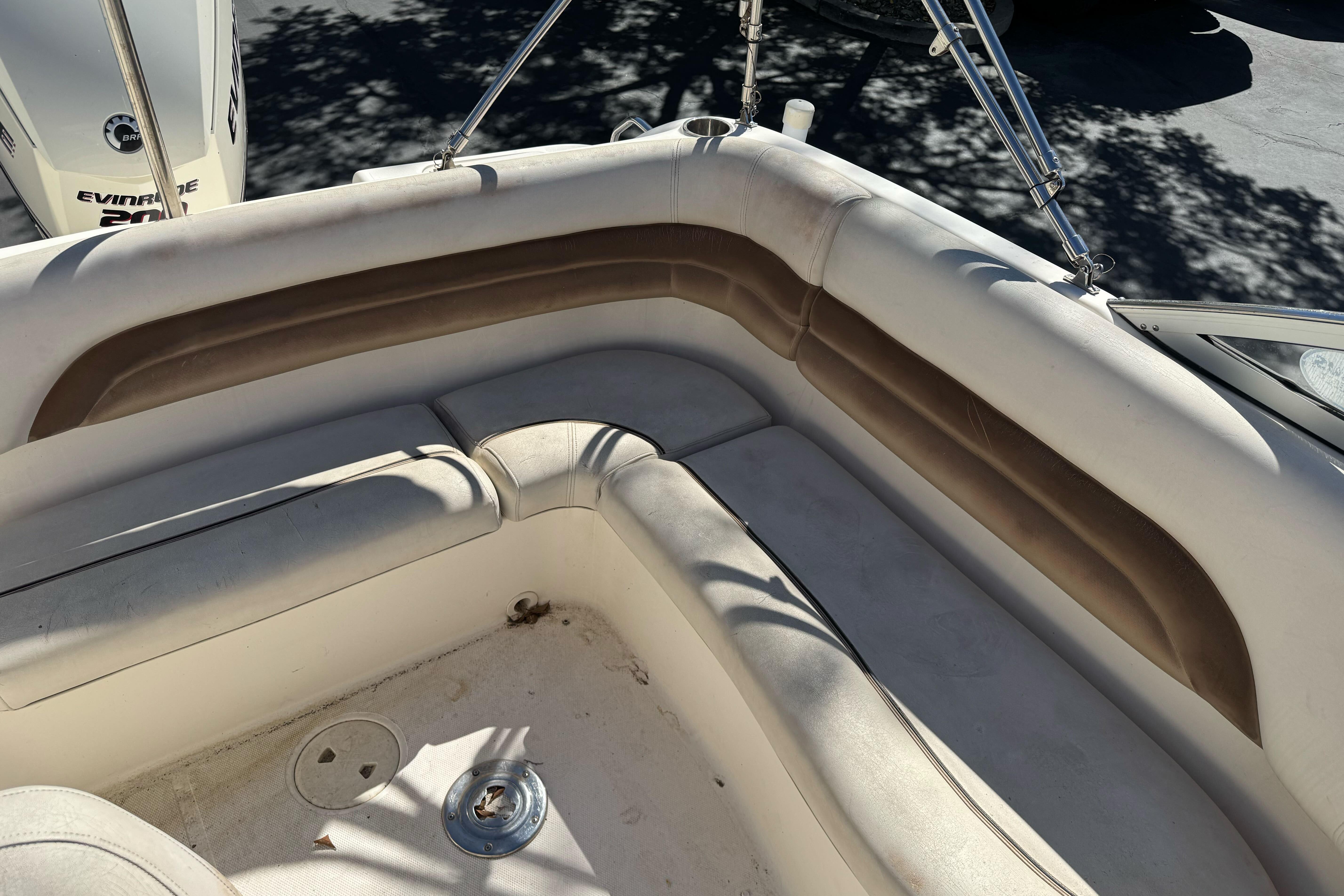 2007 Hurricane SunDeck 217 OB boat interior with cushioned seating and Evinrude motor.