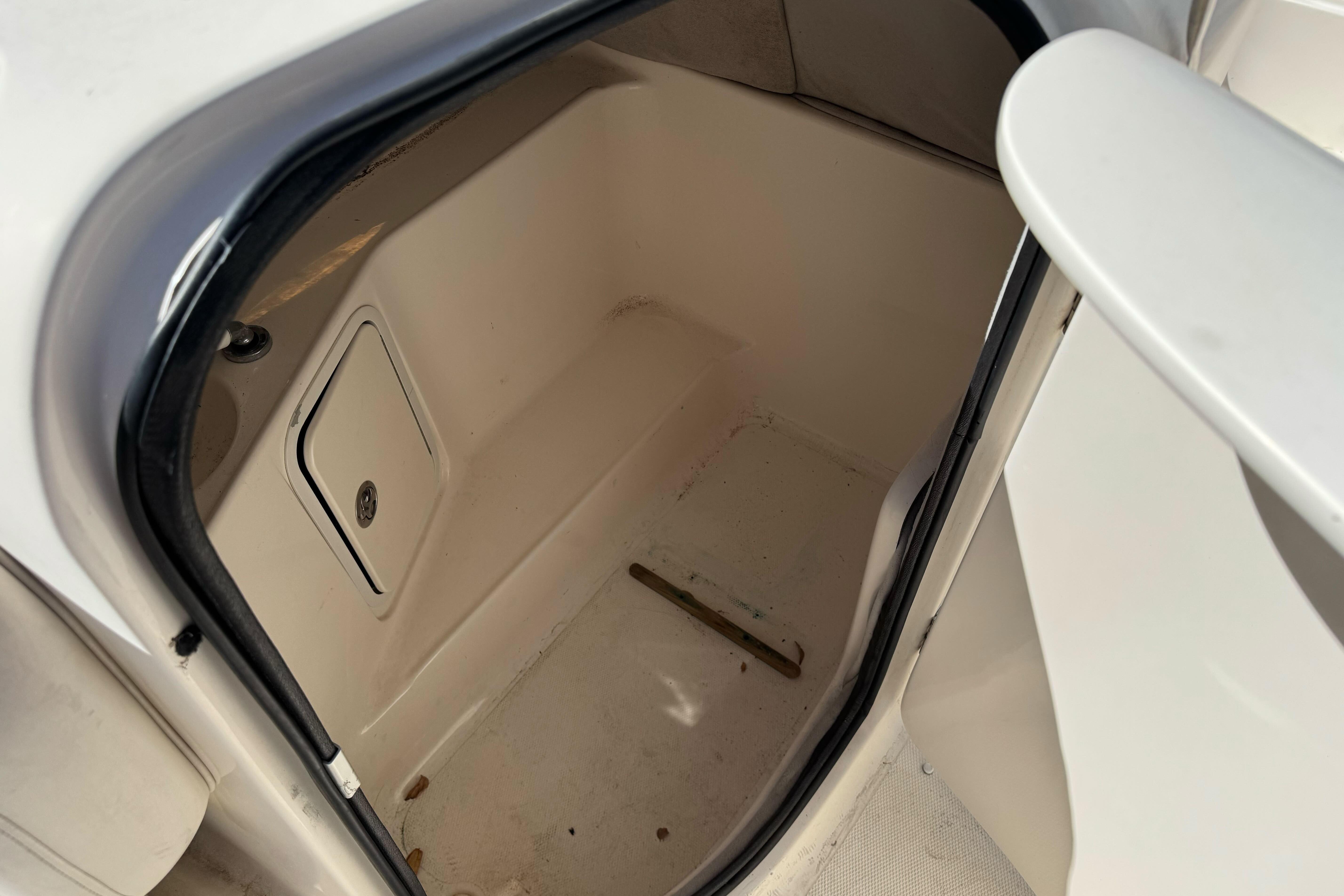 2007 Hurricane SunDeck 217 OB storage compartment interior, featuring a small access panel.