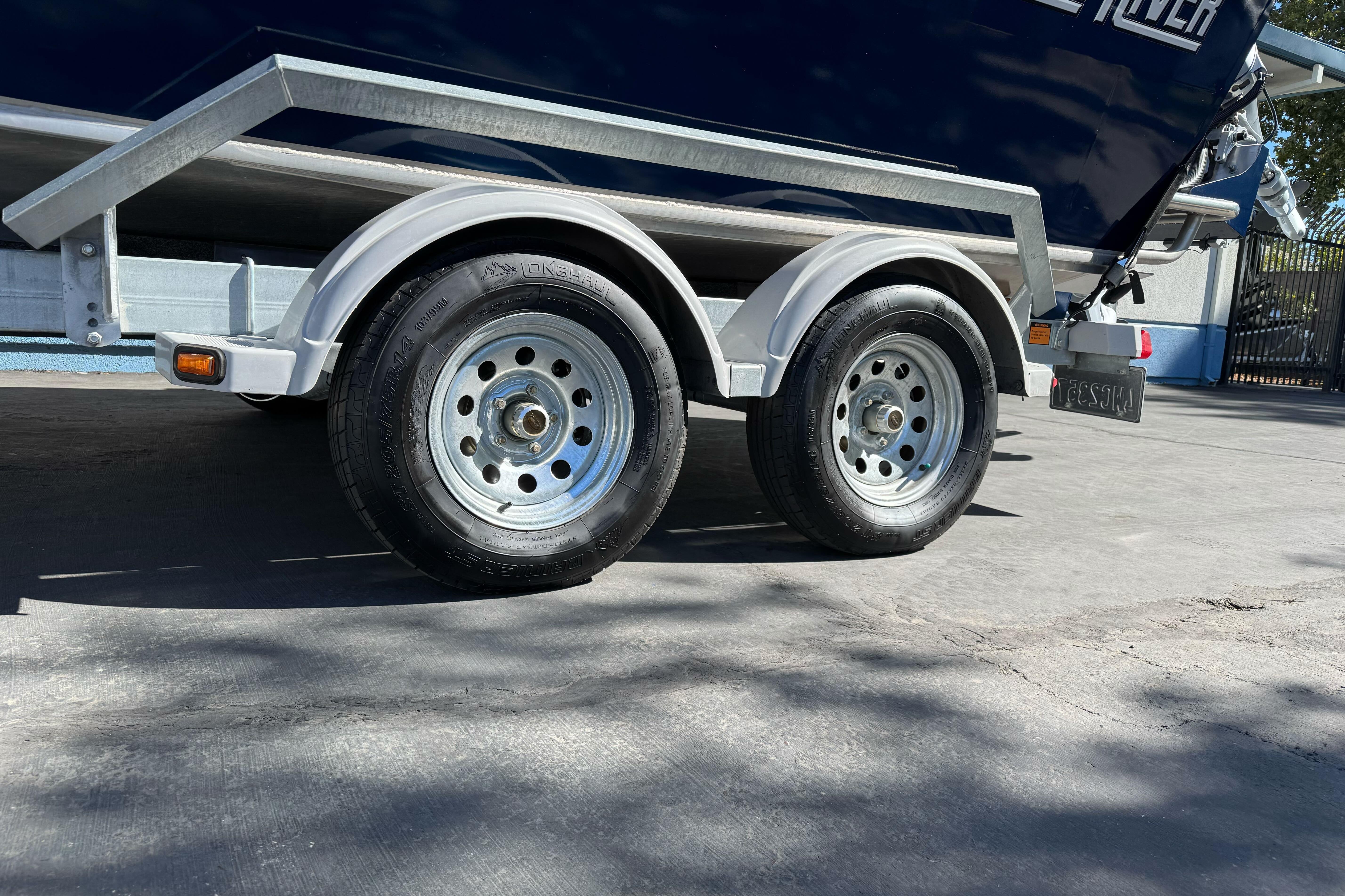Trailer of 2023 North River 21 X 84 Seahawk boat on pavement.