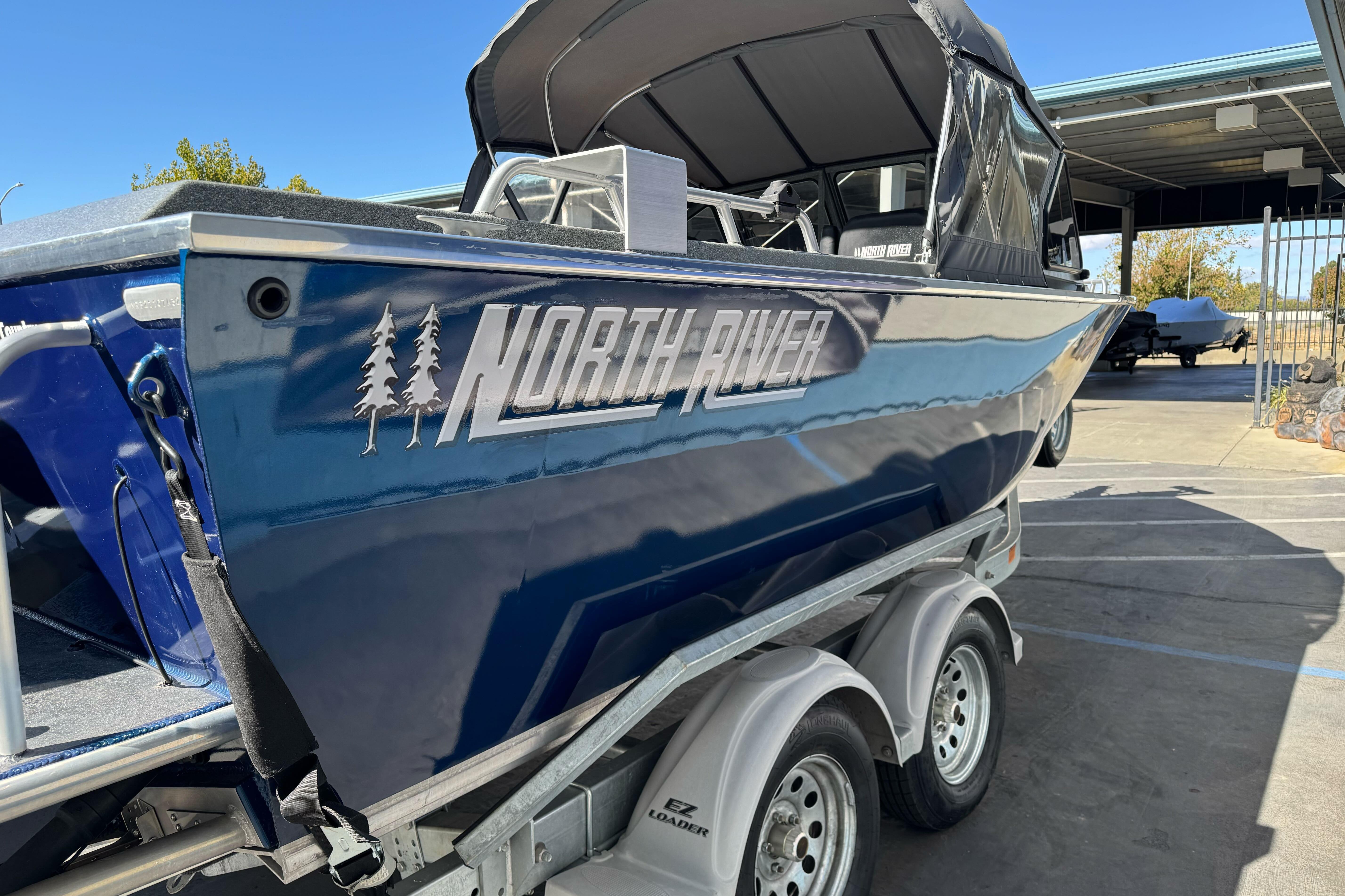 2023 North River 21 X 84 Seahawk boat on trailer, blue exterior, parked outdoors.