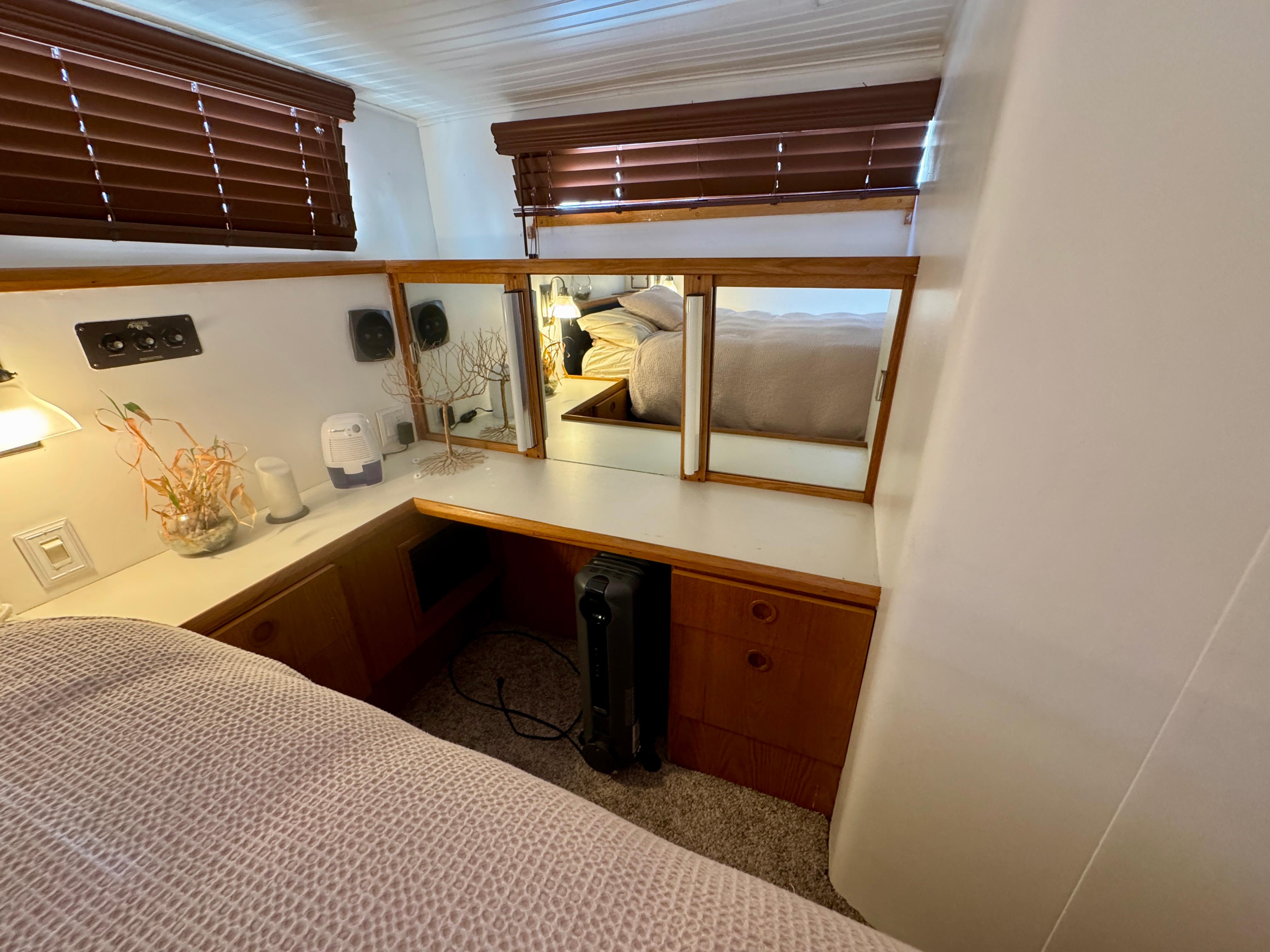 1989 Chris-Craft Catalina interior with wooden blinds, mirror, and cozy decor.