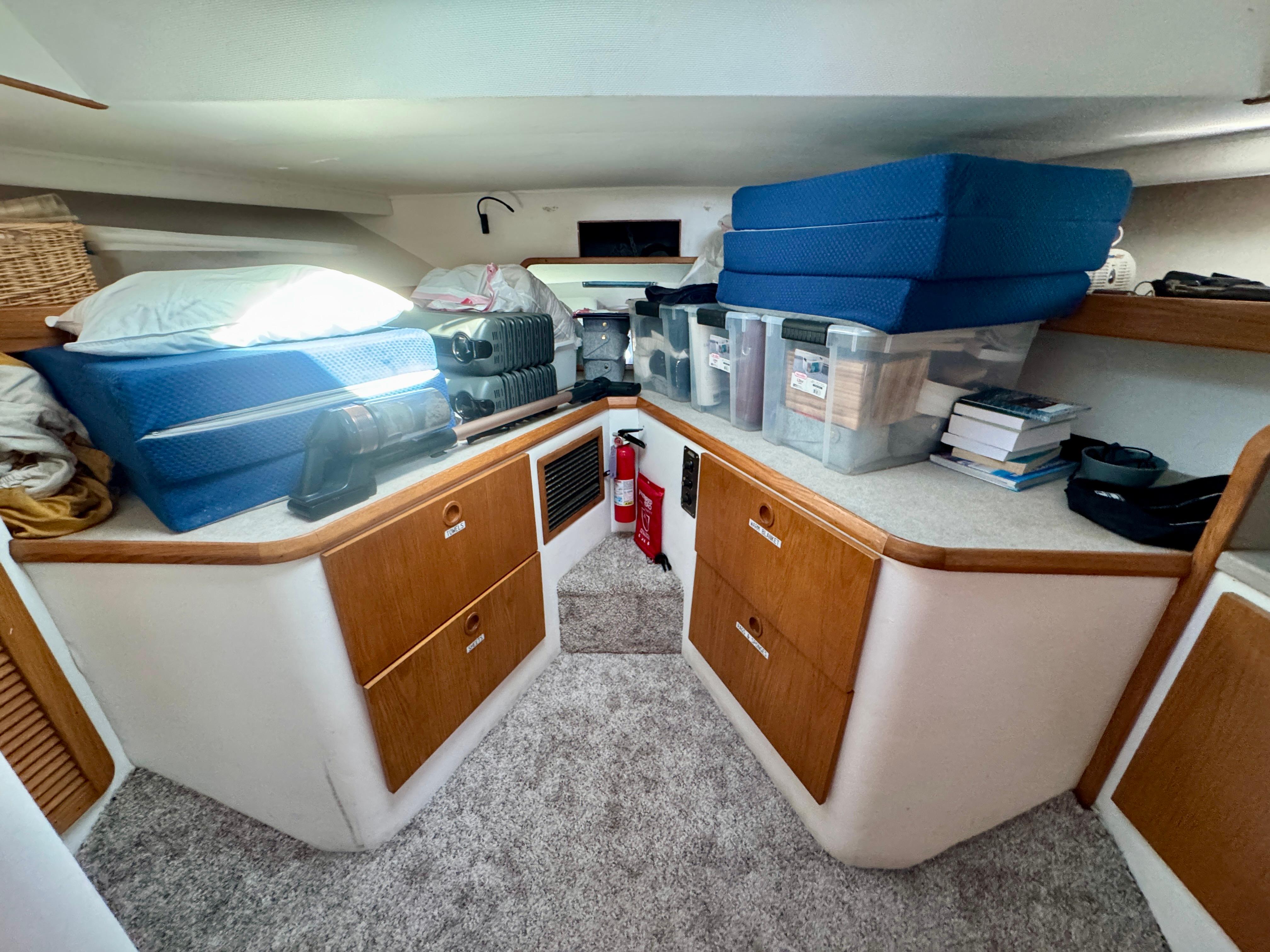 1989 Chris-Craft Catalina cabin interior with storage, cushions, and books.