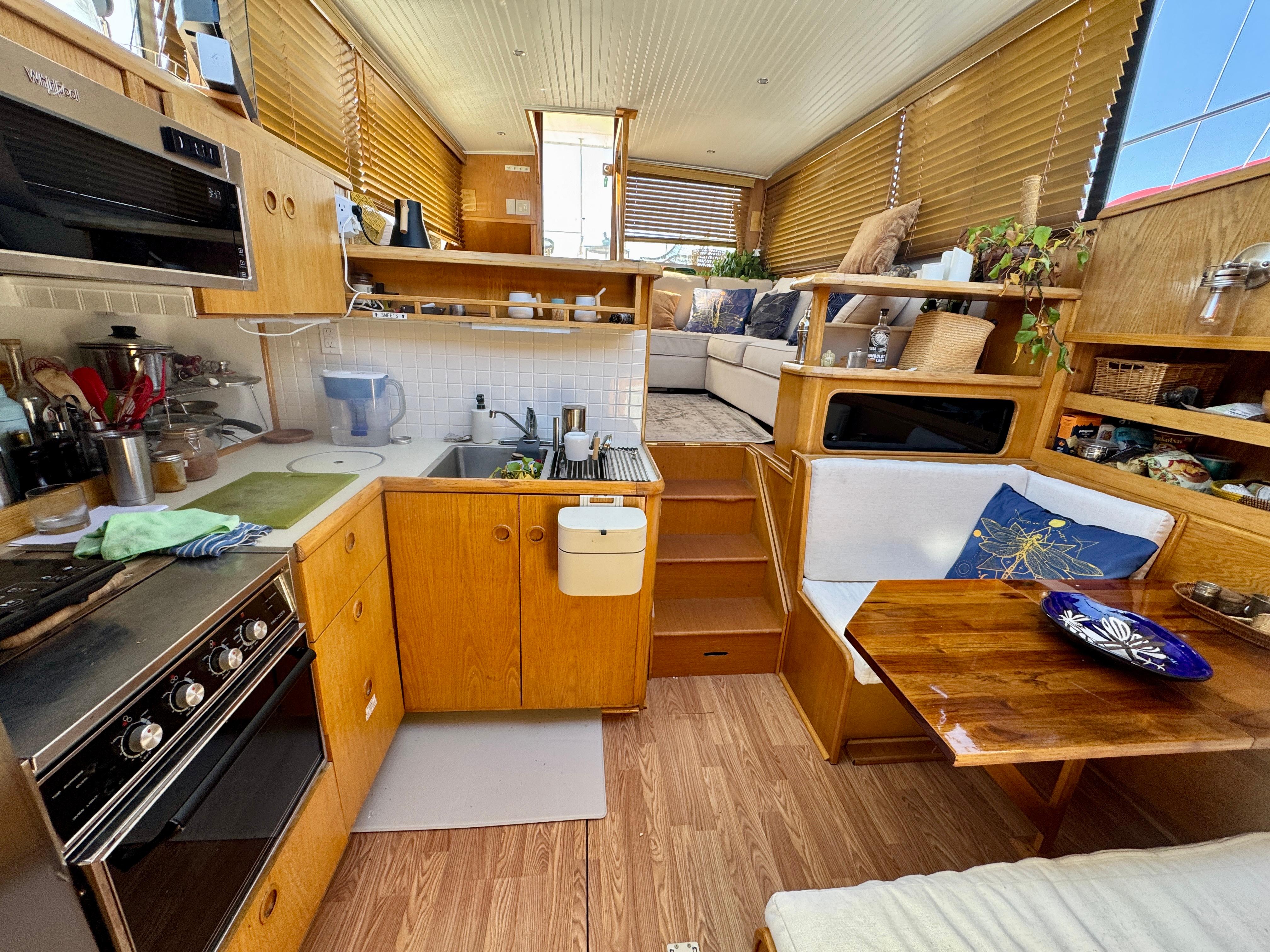 1989 Chris-Craft Catalina interior with wooden kitchen, dining area, and cozy seating.