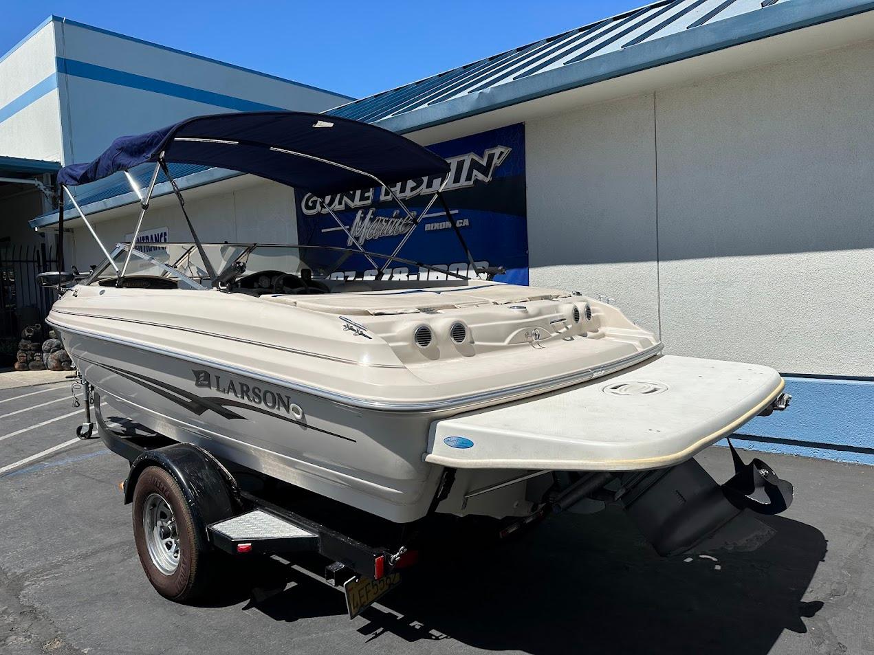 2001 Larson SEi 190 boat on trailer, parked outside a building with blue accents.