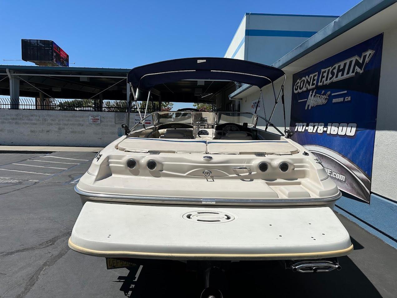 2001 Larson SEi 190 boat with canopy, parked at dealership, rear view.