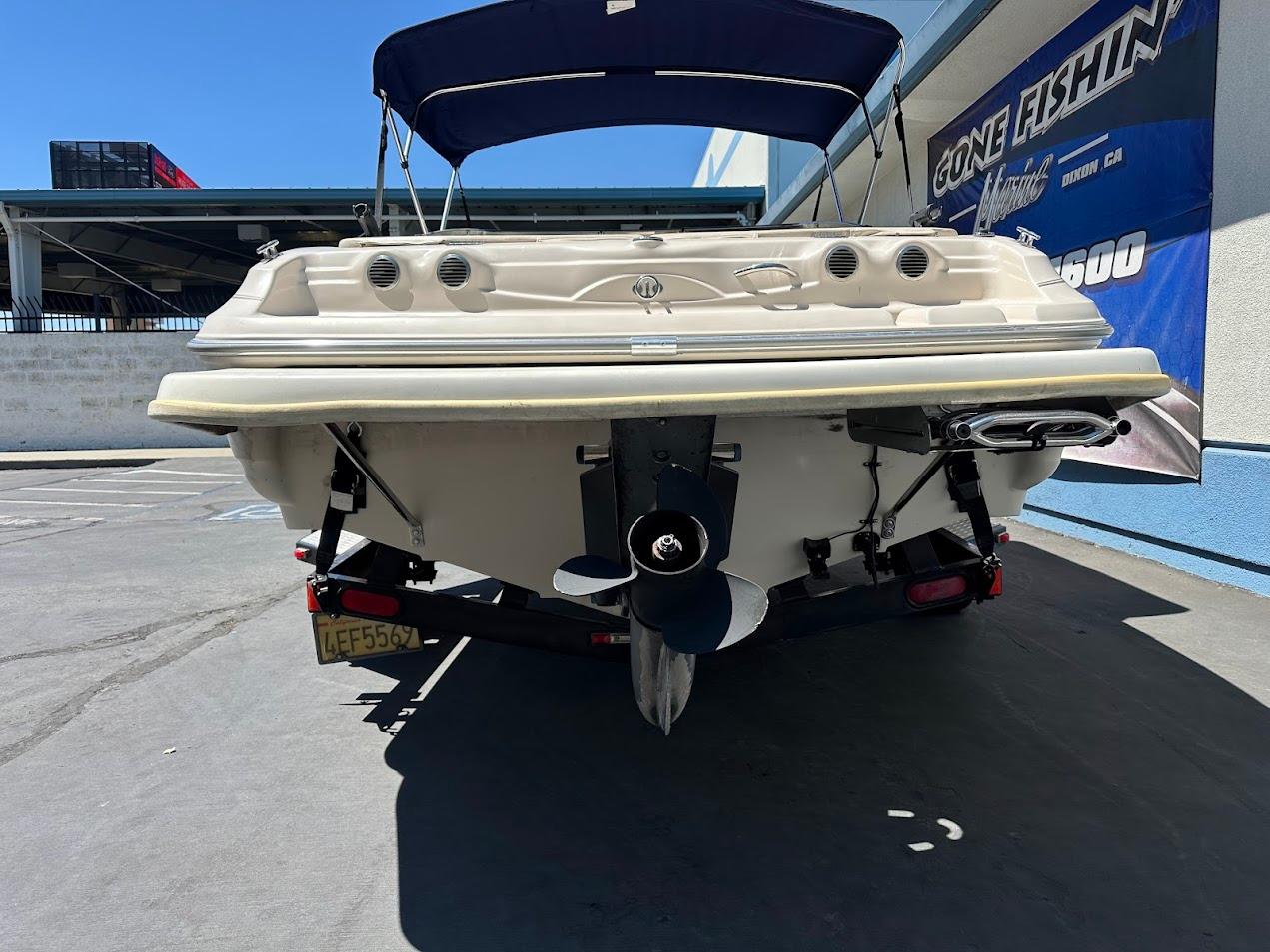 2001 Larson SEi 190 boat on trailer, rear view with propeller and canopy.