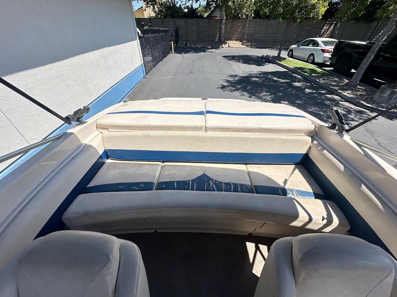 2001 Larson SEi 190 boat interior with blue and white seating, parked in driveway.