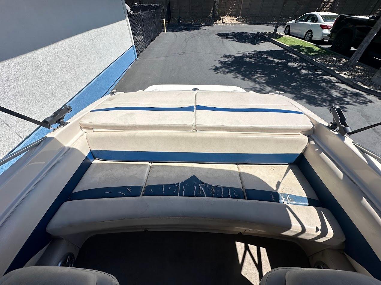 2001 Larson SEi 190 boat interior with blue and white seating, parked outdoors.