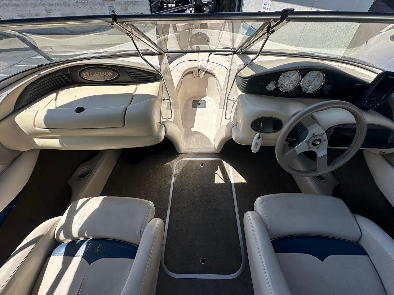 Interior of a 2001 Larson SEi 190 boat, featuring steering wheel and dashboard controls.
