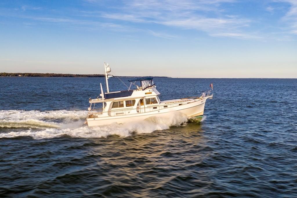 2003 Grand Banks 46 Europa cruising on open water under a clear blue sky.