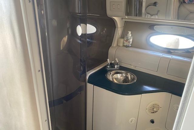 Interior of a 1995 Regal 402 boat bathroom with sink and mirror.