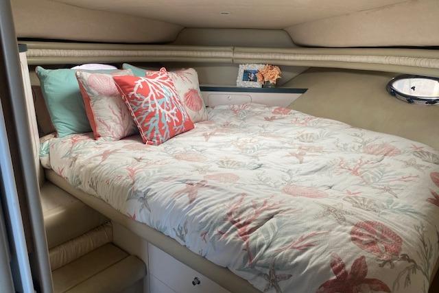 Cozy 1995 Regal 402 yacht cabin with floral bedding and decorative pillows.