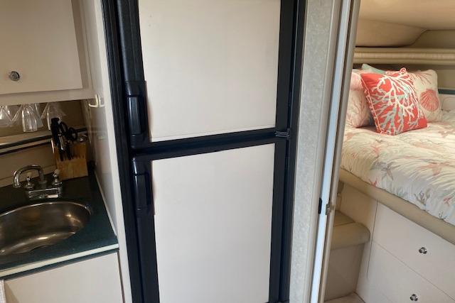 Interior of a 1995 Regal 402 boat with kitchenette and cozy bedroom.