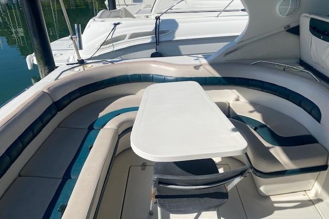 1995 Regal 402 boat interior with curved seating and table, docked at marina.