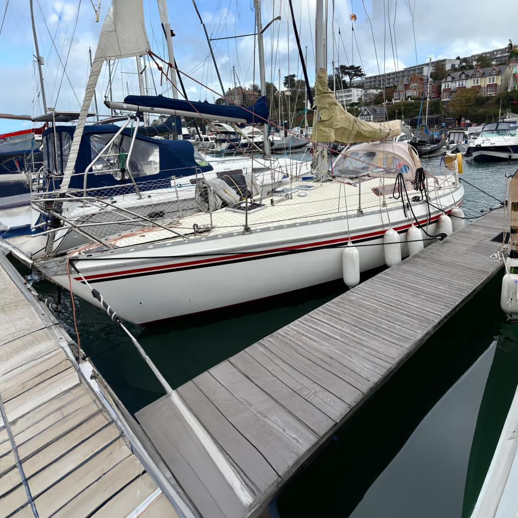 1981 Jeanneau Melody sailboat docked at a marina, surrounded by other boats.
