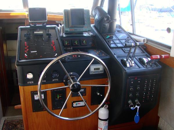 1987 Bayliner 3888 Motoryacht helm with steering wheel, controls, and navigation equipment.
