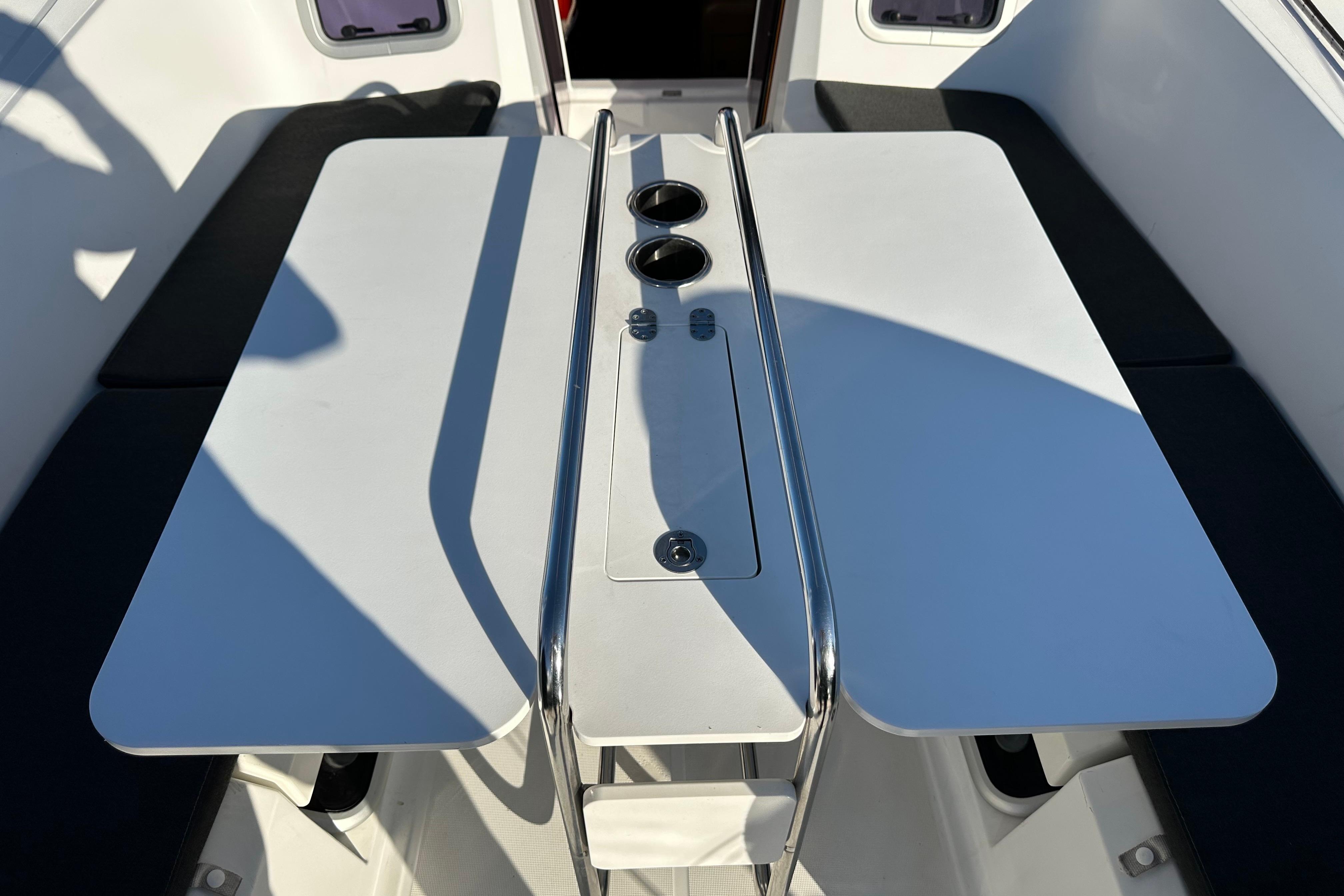 Cockpit table on 2021 Jeanneau Sun Odyssey 349 sailboat, featuring dual cup holders.