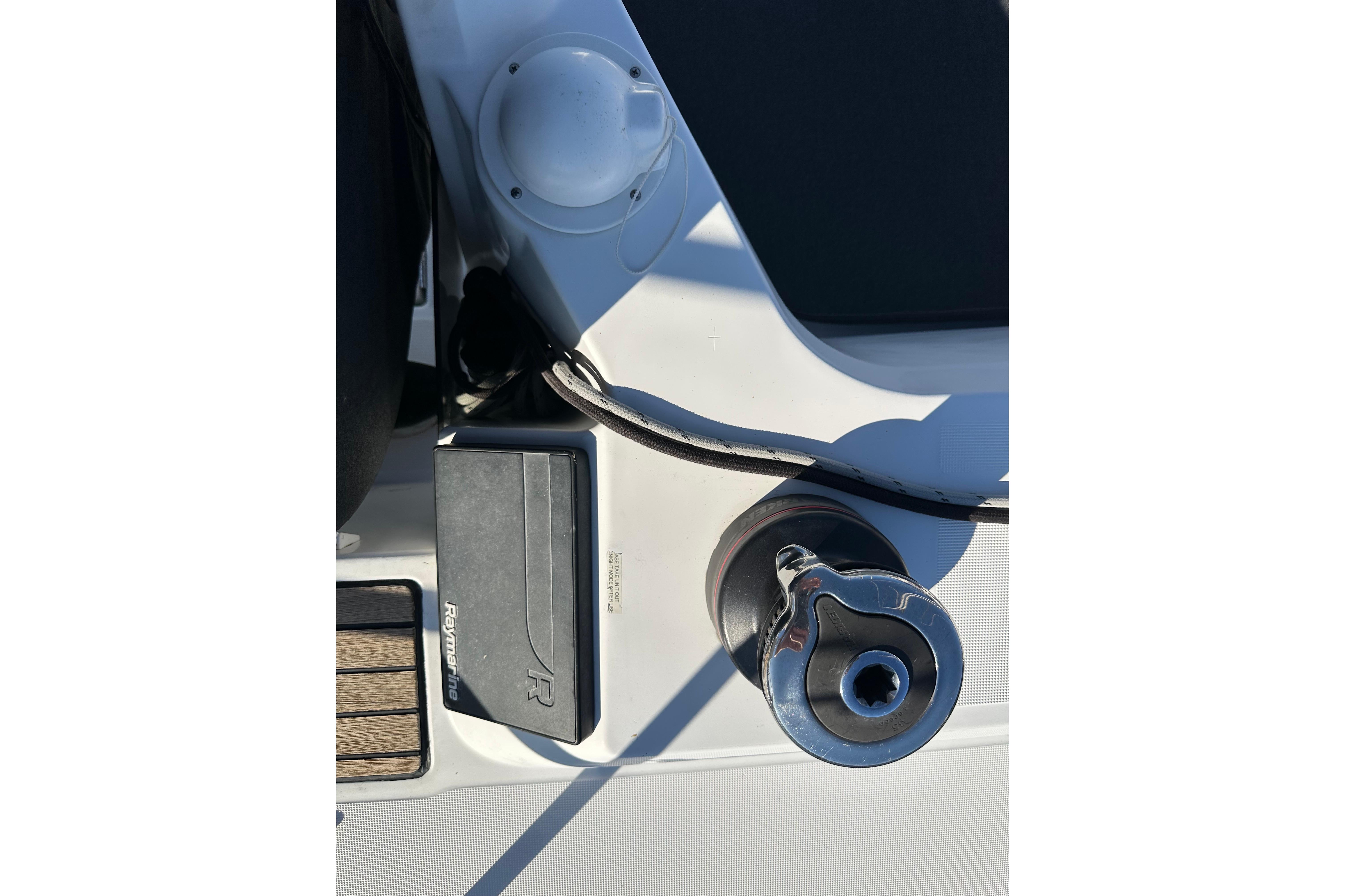 Close-up of Jeanneau Sun Odyssey 349 sailboat deck equipment, featuring a winch and Raymarine device.