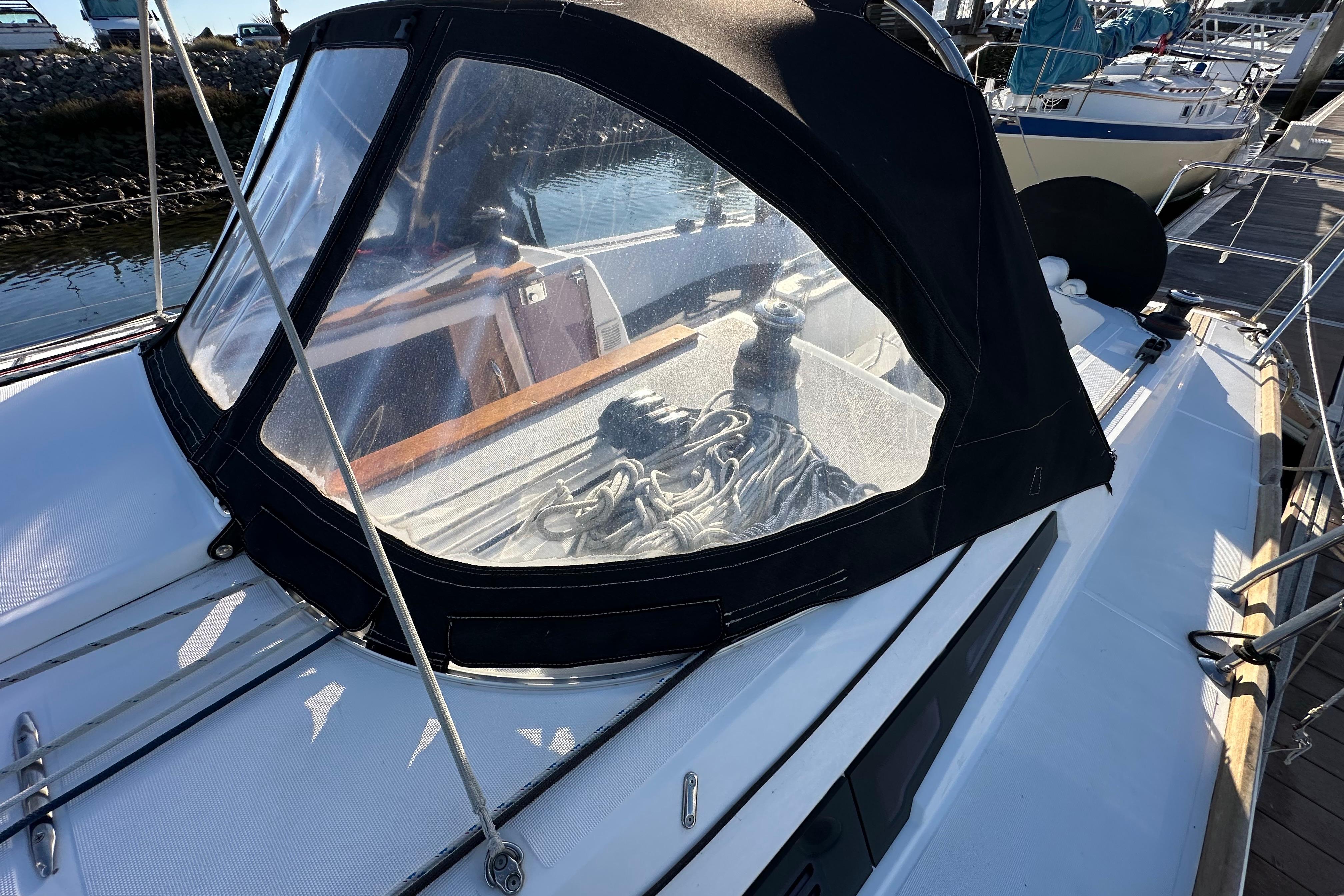 2021 Jeanneau Sun Odyssey 349 sailboat with cockpit cover, docked at marina.