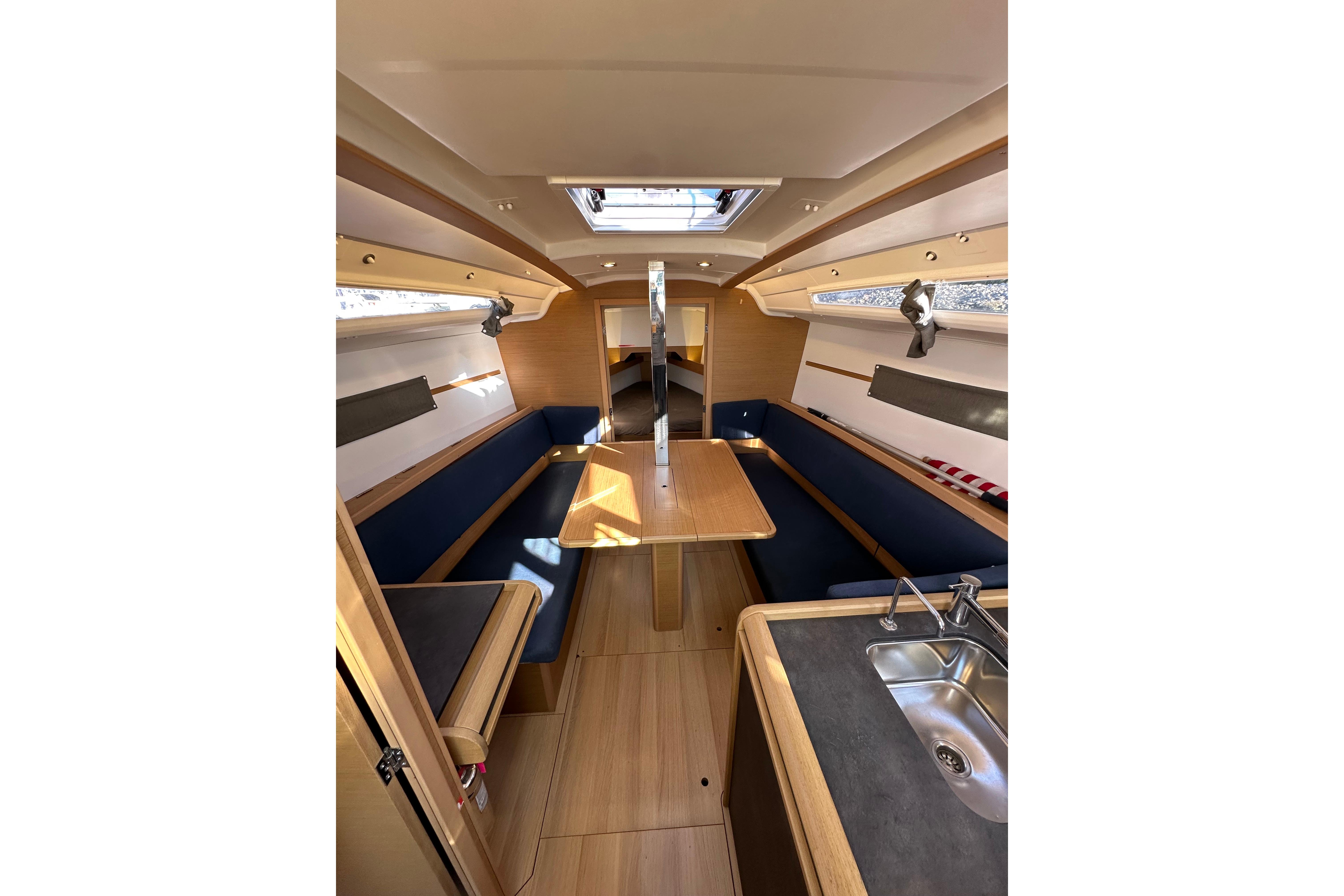 Interior of 2021 Jeanneau Sun Odyssey 349 sailboat, featuring a cozy dining area and kitchenette.