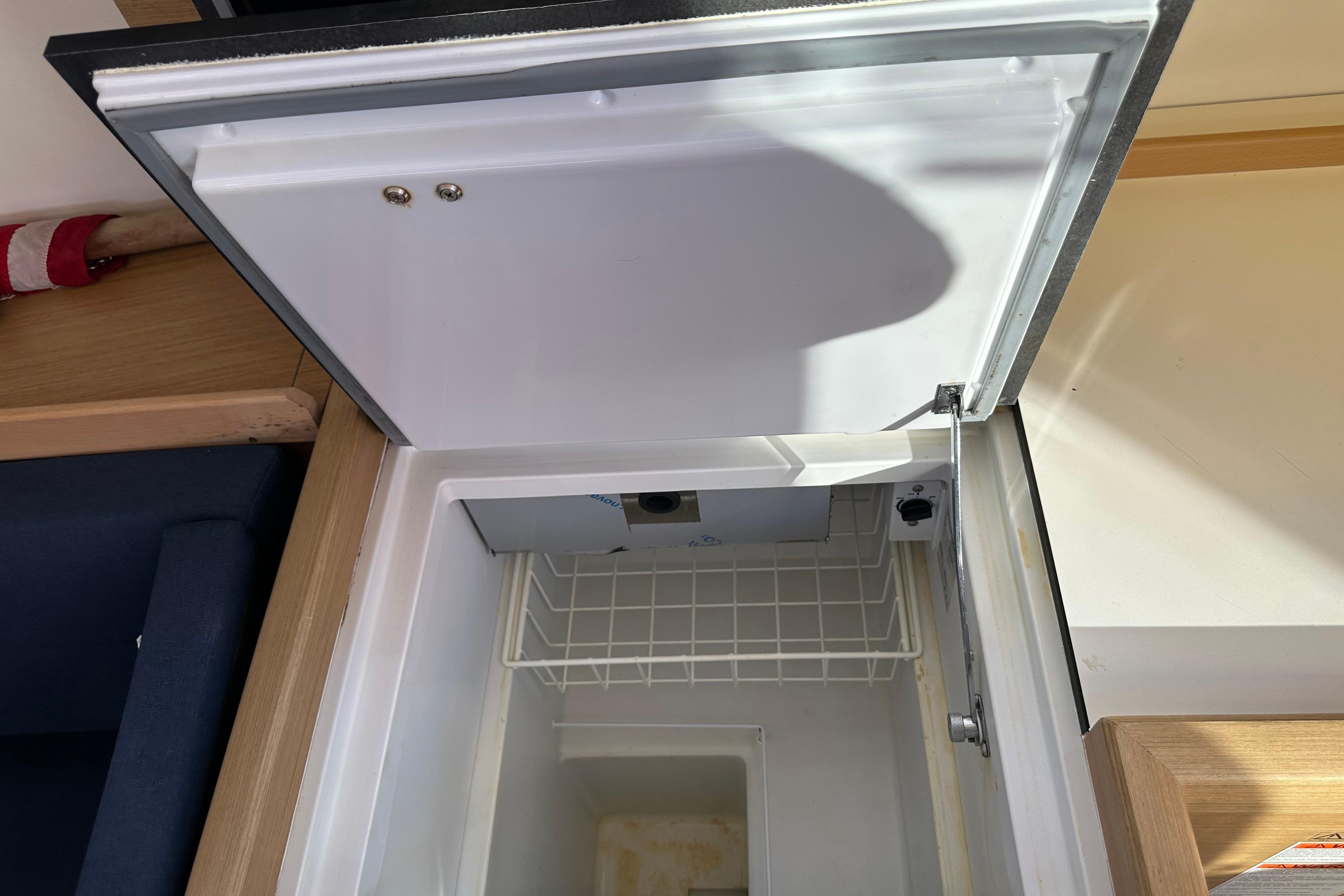Open refrigerator in 2021 Jeanneau Sun Odyssey 349 yacht interior.