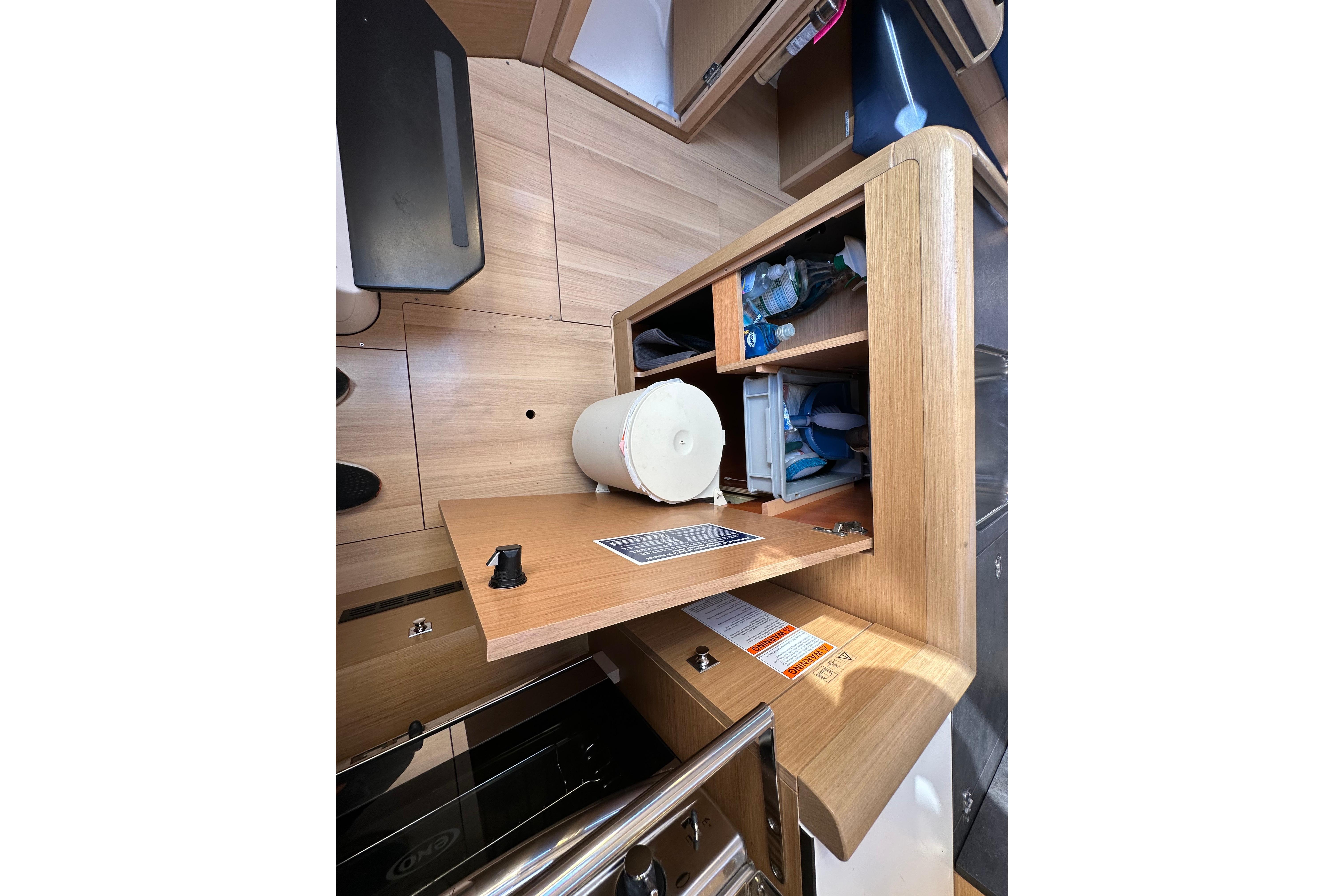 Interior of 2021 Jeanneau Sun Odyssey 349 yacht with wooden cabinetry and storage compartments.