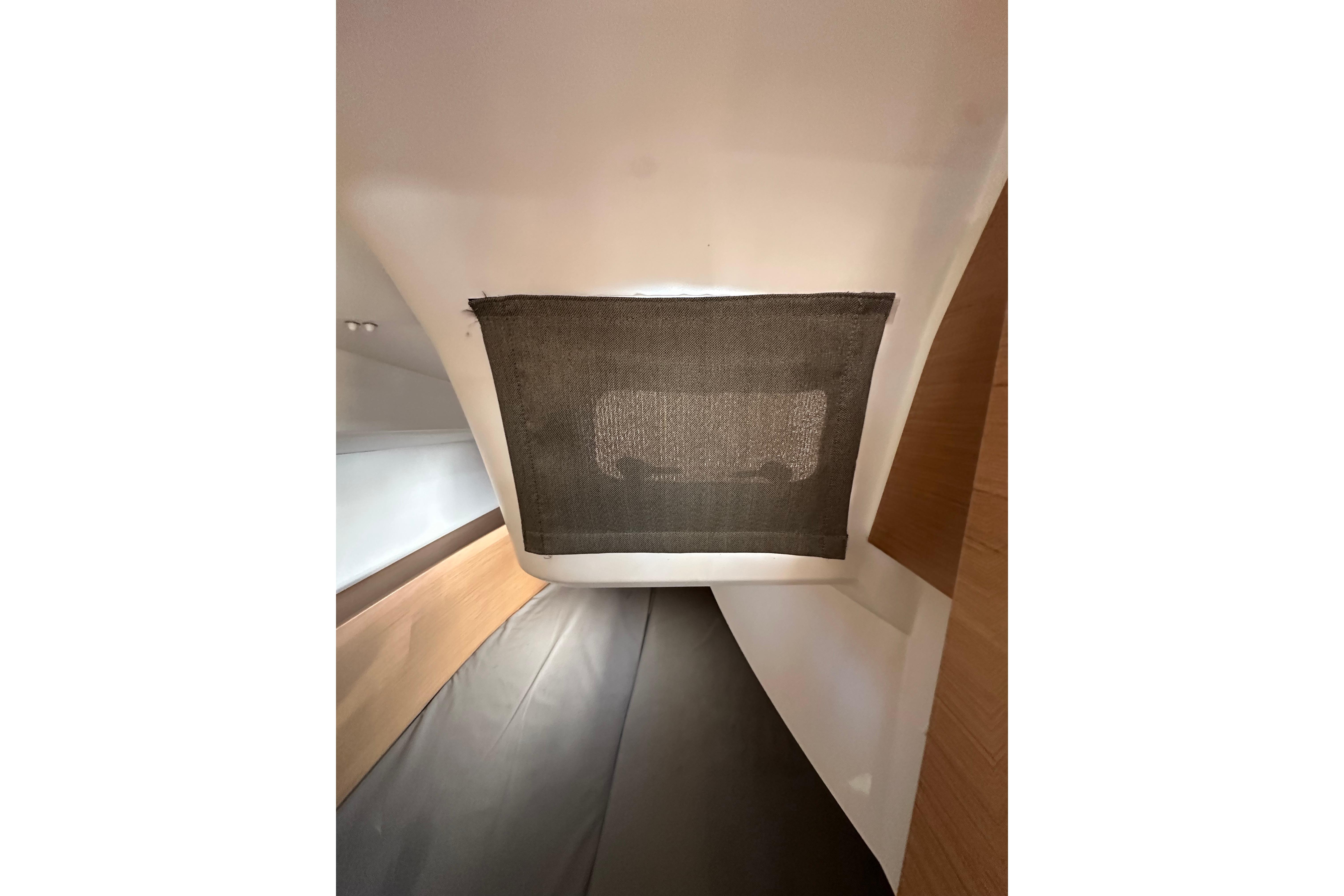 Interior view of 2021 Jeanneau Sun Odyssey 349 sailboat cabin with window shade.