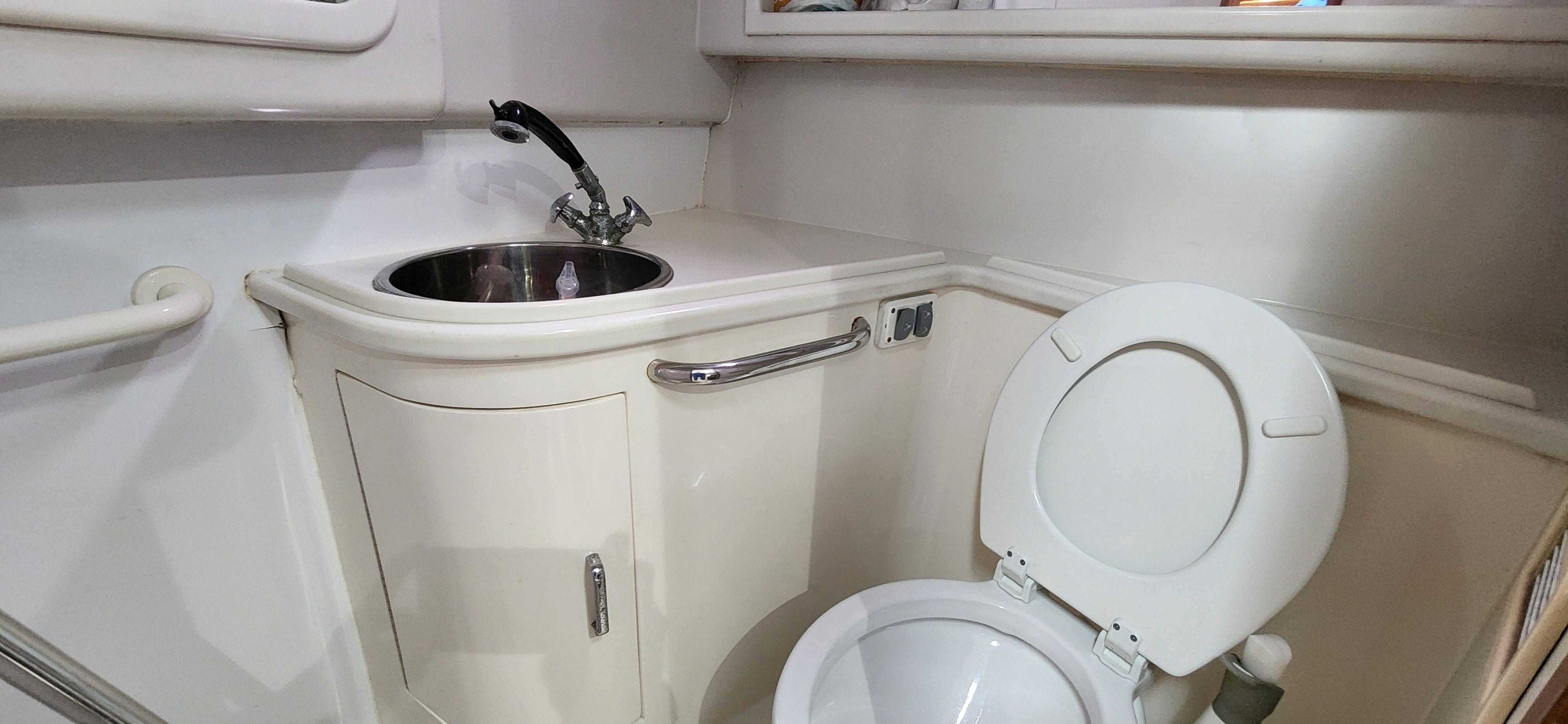 Cabo-35 Express 1995 -AL-US-Compact bathroom in a 1995 Cabo 35 Express boat with sink and toilet.-9547451 | Thumbnail