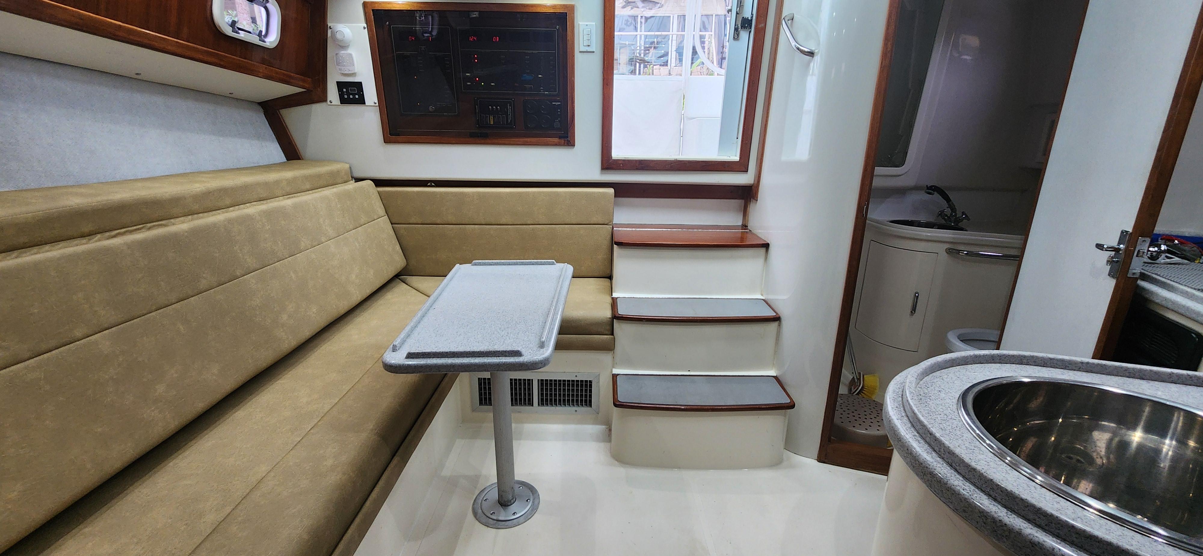 Cabo-35 Express 1995 -AL-US-Interior of 1995 Cabo 35 Express boat with seating, table, and kitchenette.-9547451 | Thumbnail