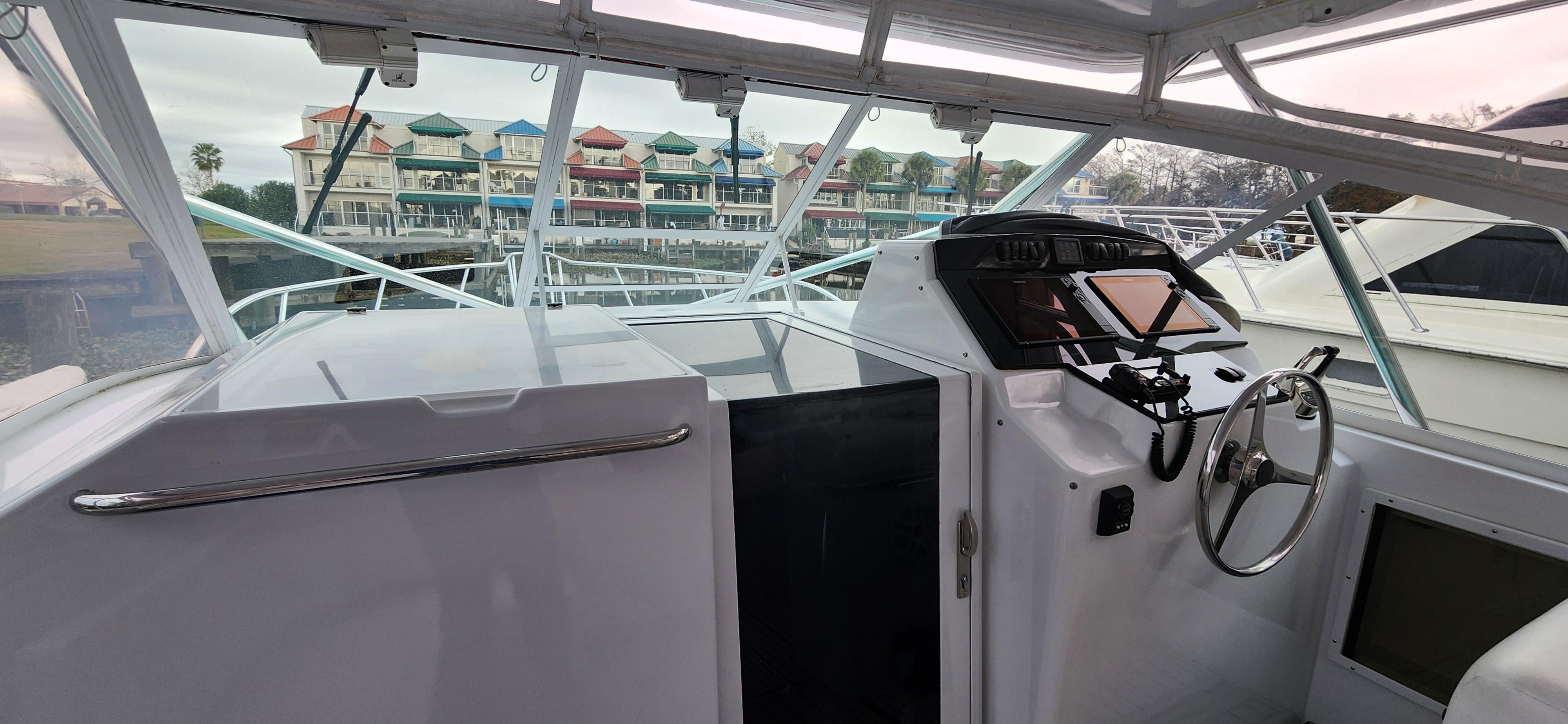 Cabo-35 Express 1995 -AL-US-1995 Cabo 35 Express boat interior with steering wheel and marina view.-9547451 | Thumbnail