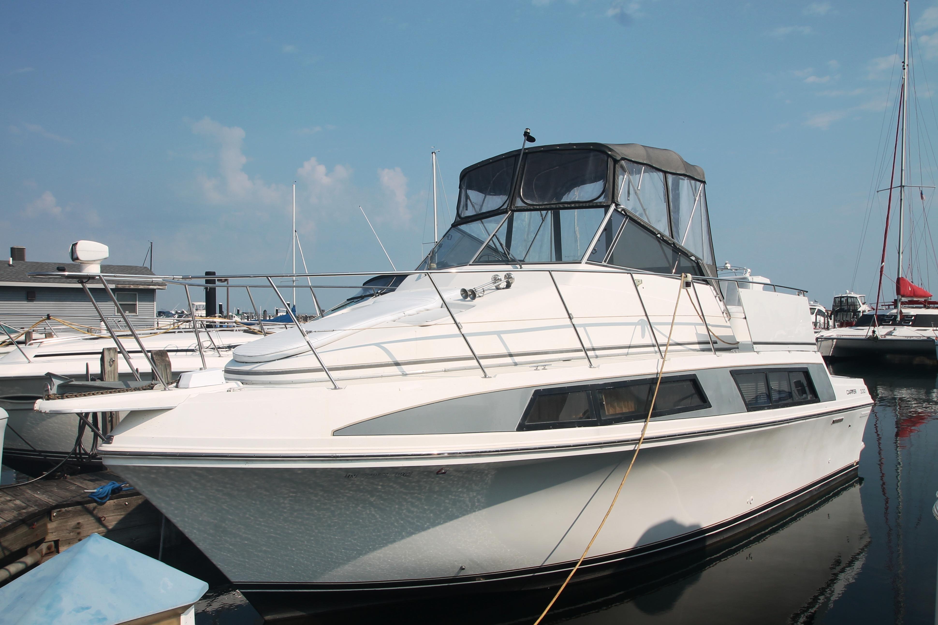 1995 Carver 330 Mariner yacht docked at marina under clear blue sky.