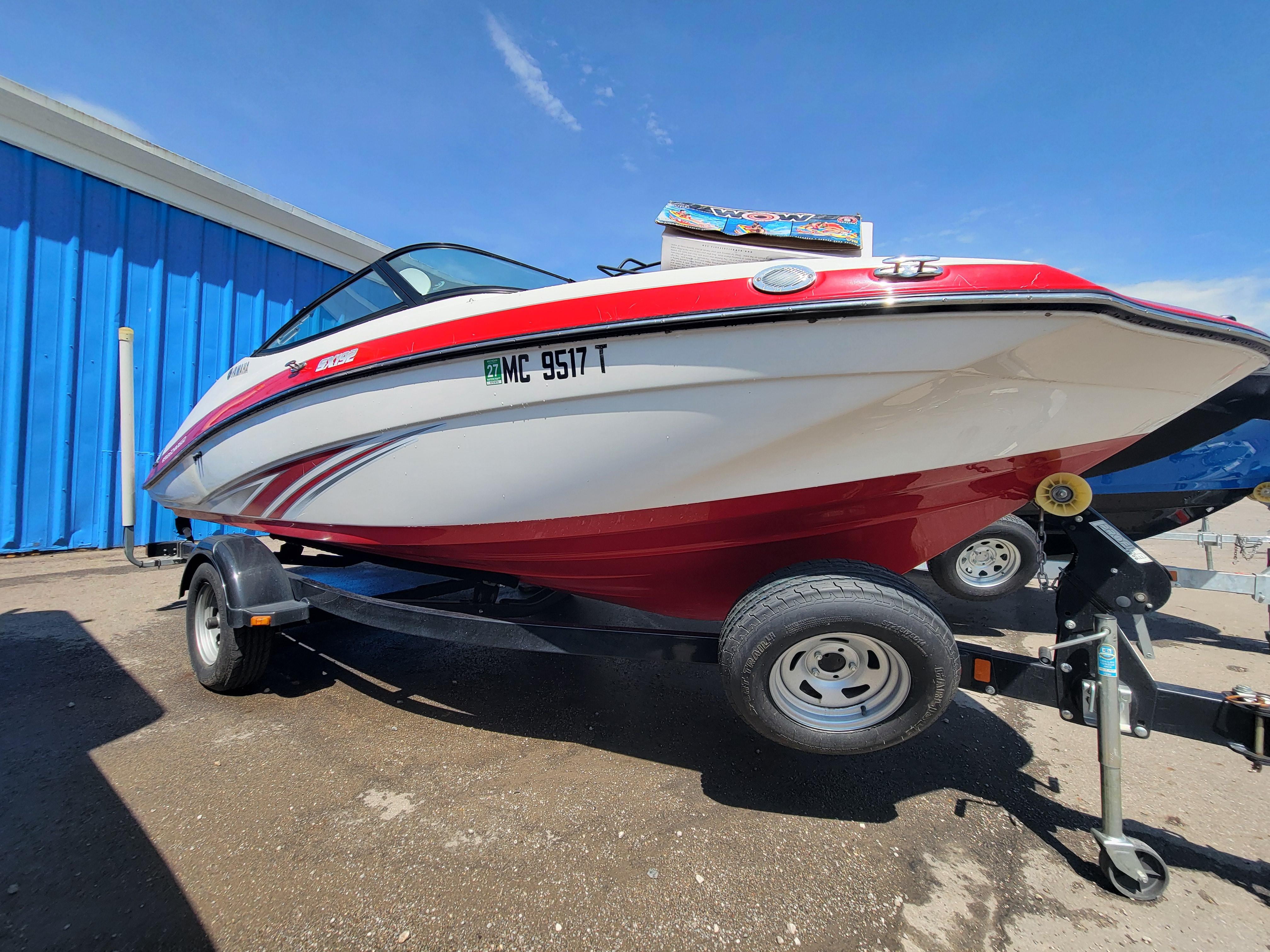 2016 Yamaha Boats SX192 on trailer, red and white, parked outdoors.