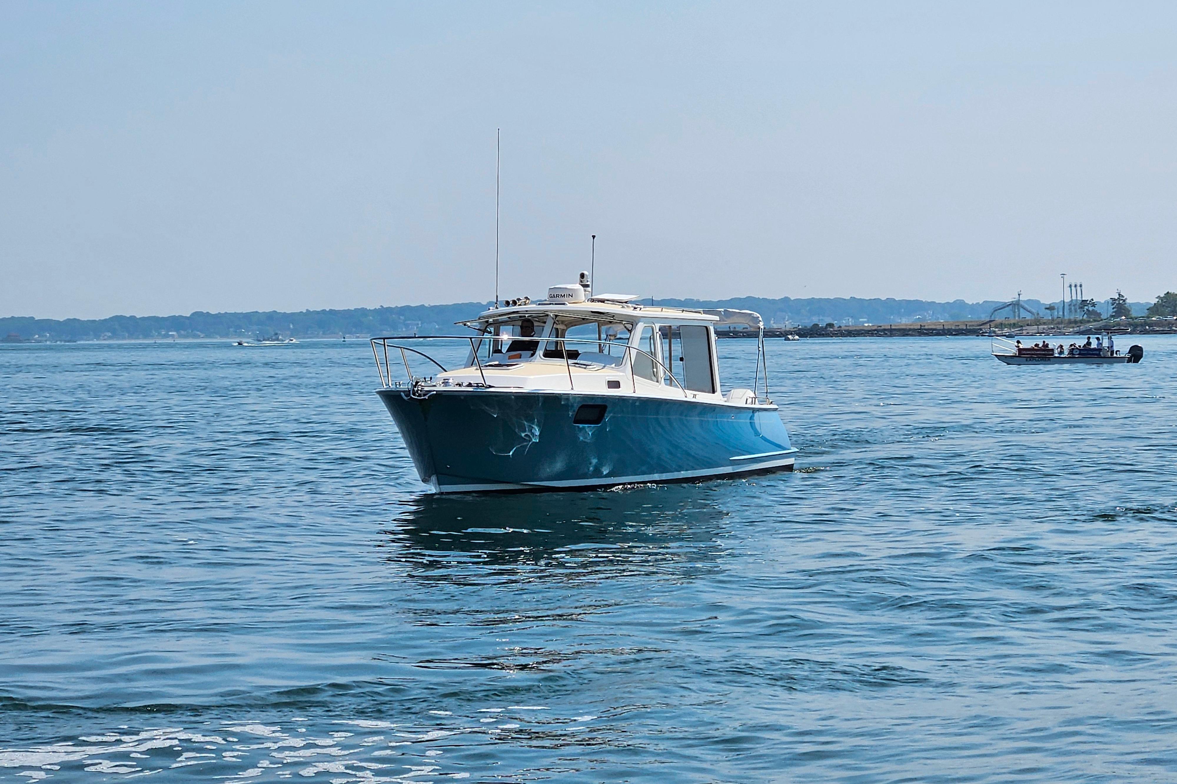 2023 MJM 35 boat cruising on calm blue waters under a clear sky.